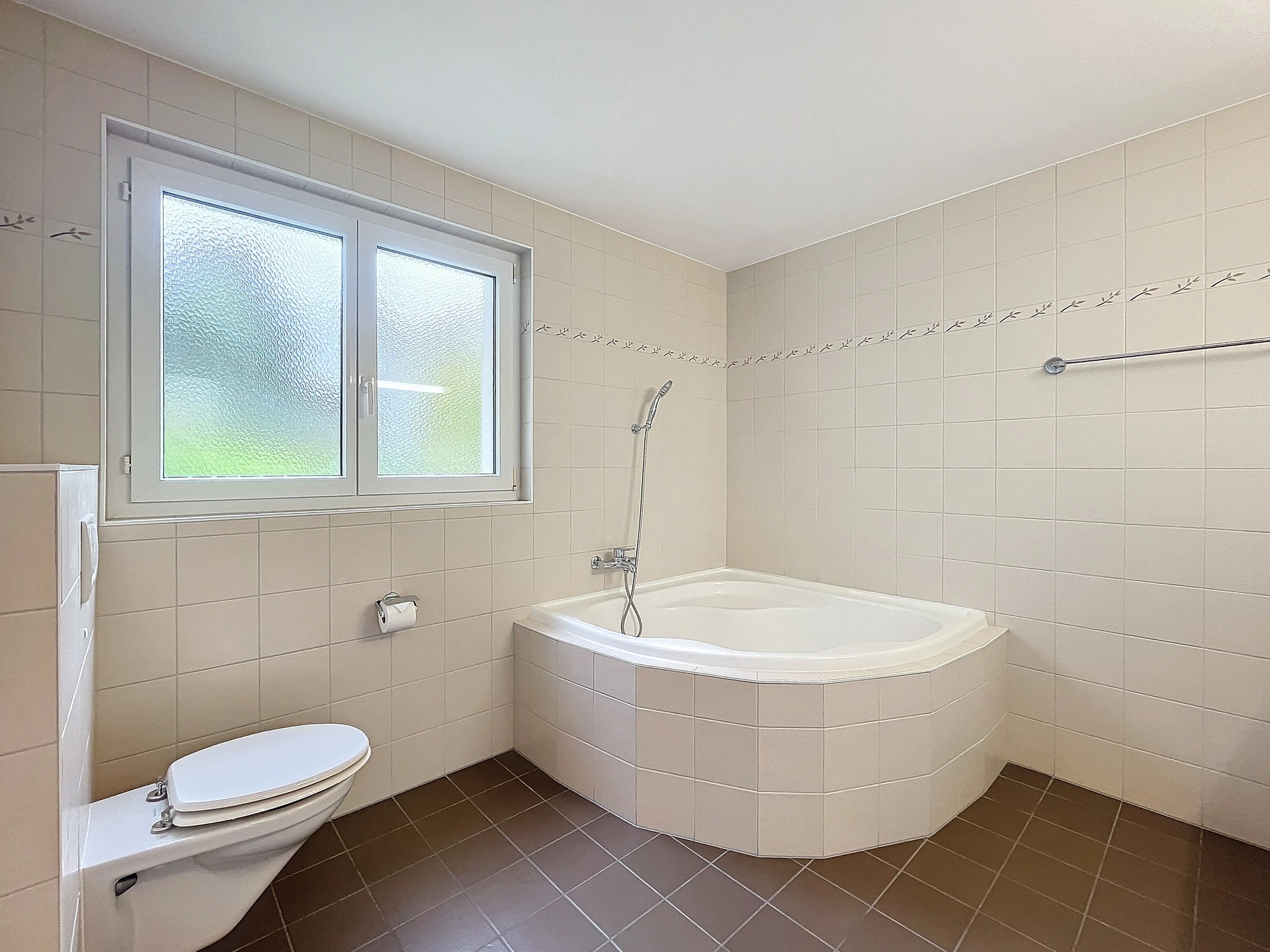 Badezimmer mit Eckbadewanne und WC
