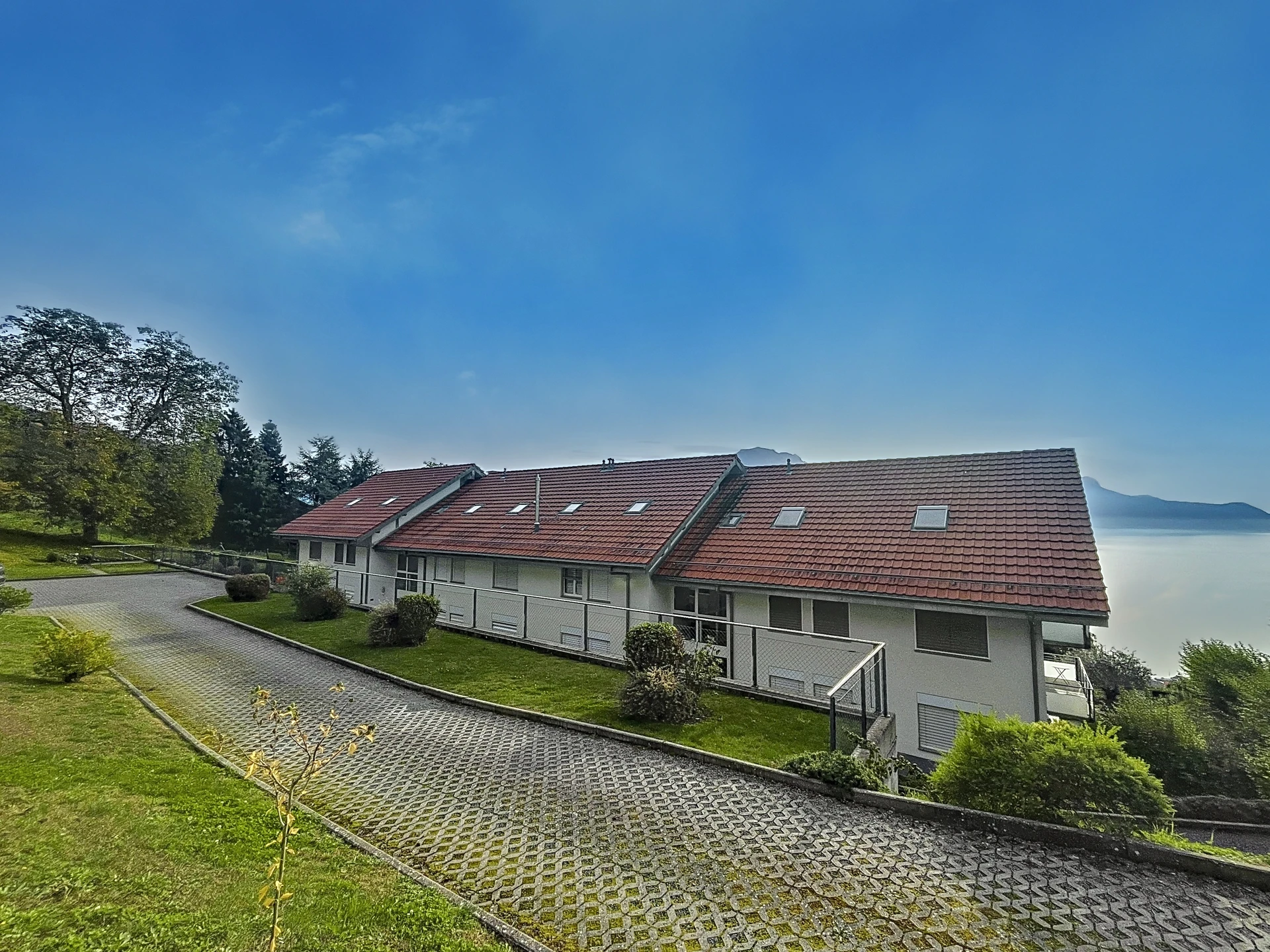 Seeblick auf ein Wohngebäude mit rotem Satteldach