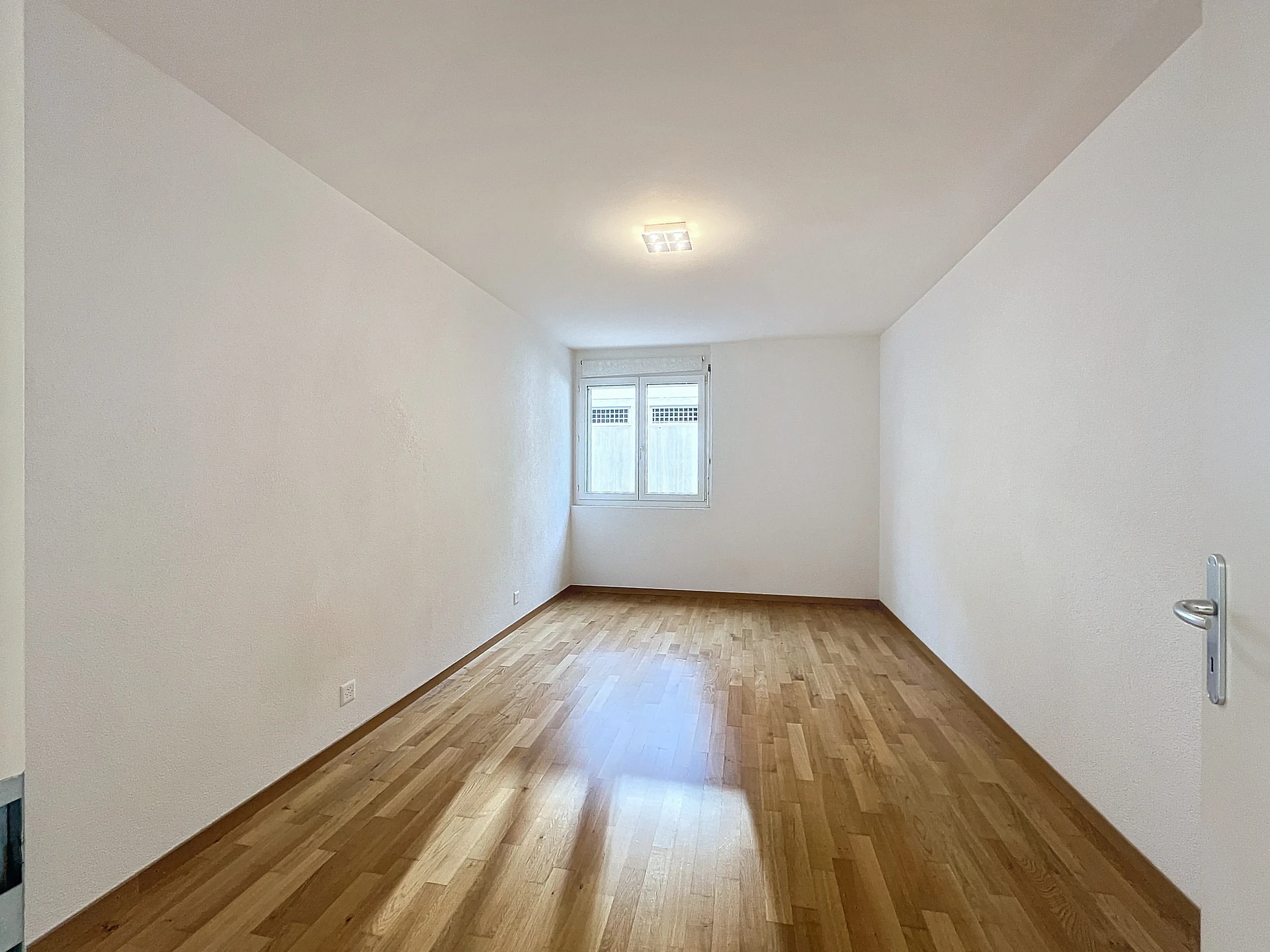 Helles, leeres Zimmer mit Holzfußboden