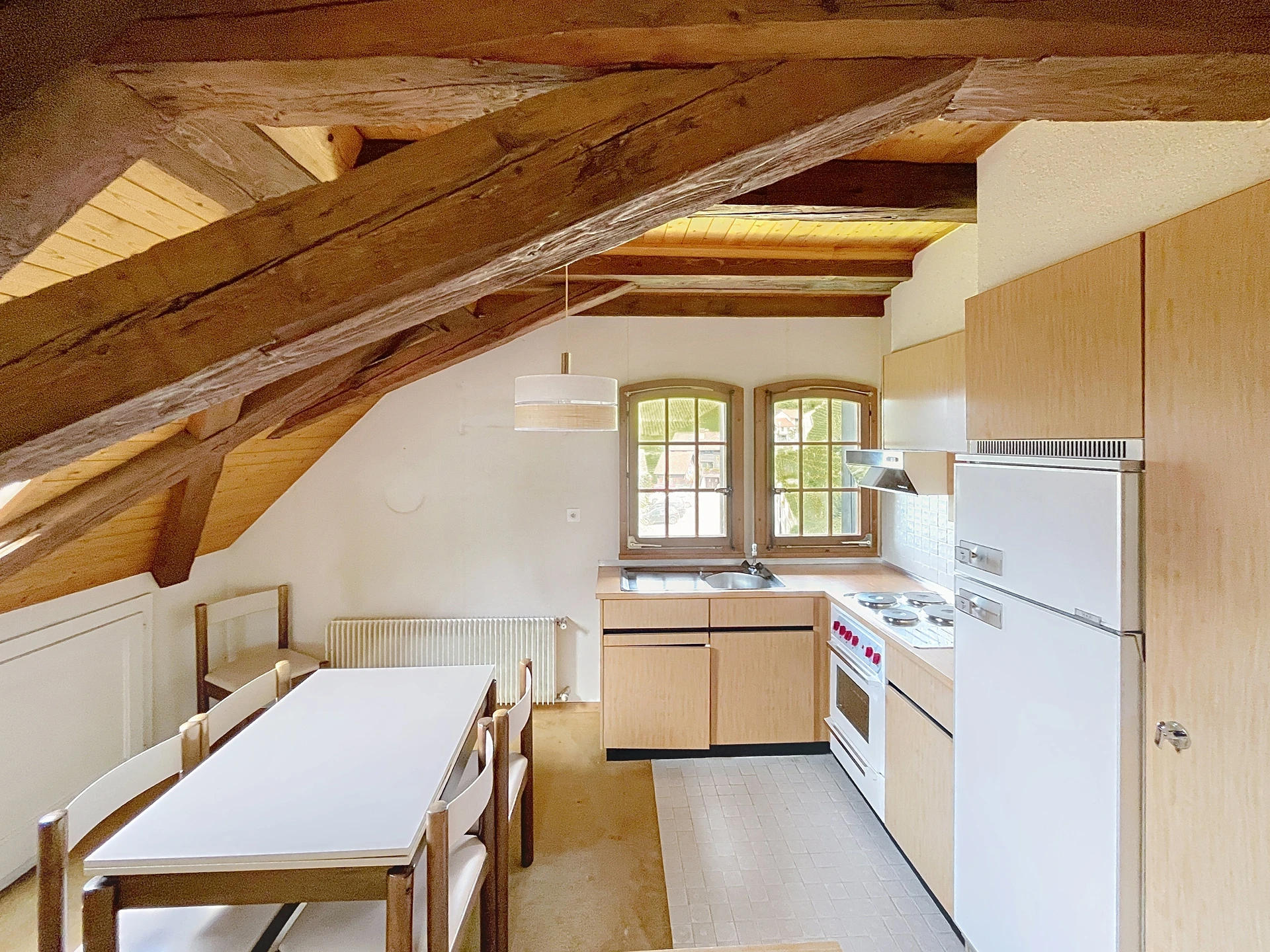 Dachgeschossküche mit sichtbaren Holzbalken