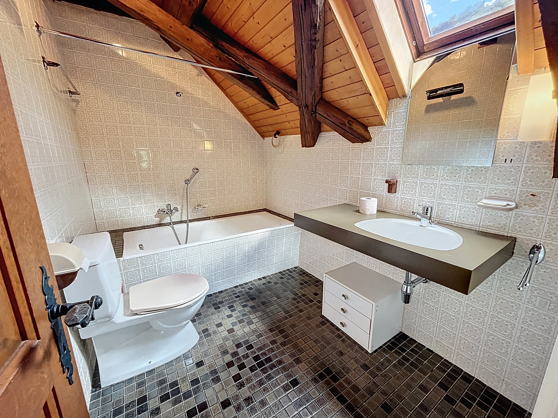 Dachgeschoss-Badezimmer mit Badewanne, WC und Waschtisch