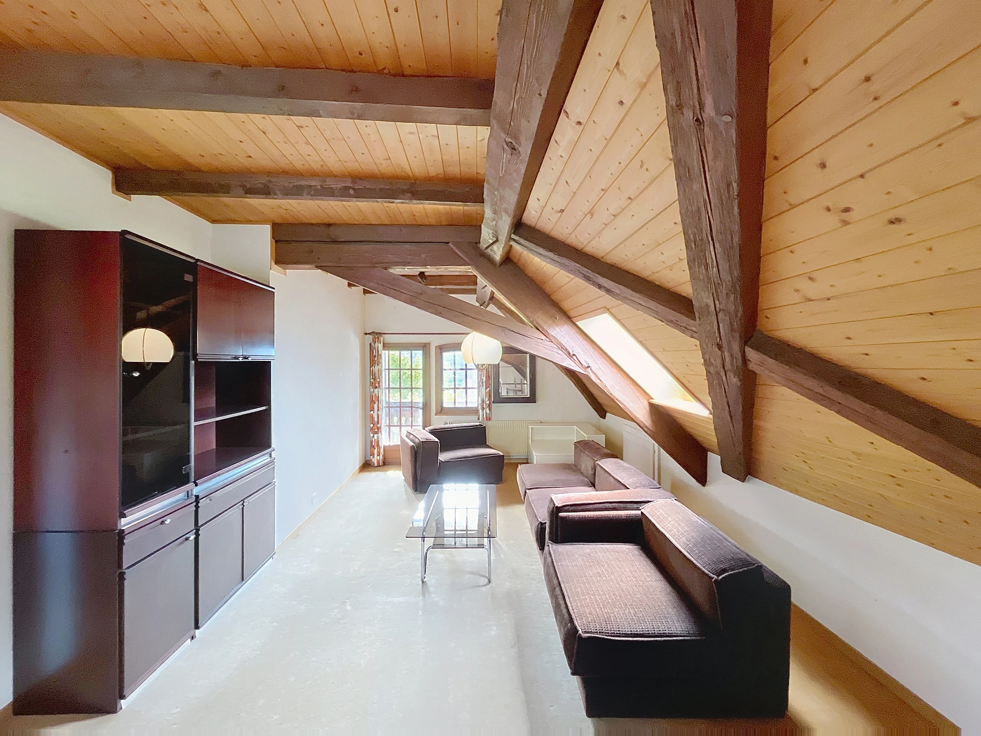 Dachgeschoss-Wohnzimmer mit sichtbaren Holzbalken