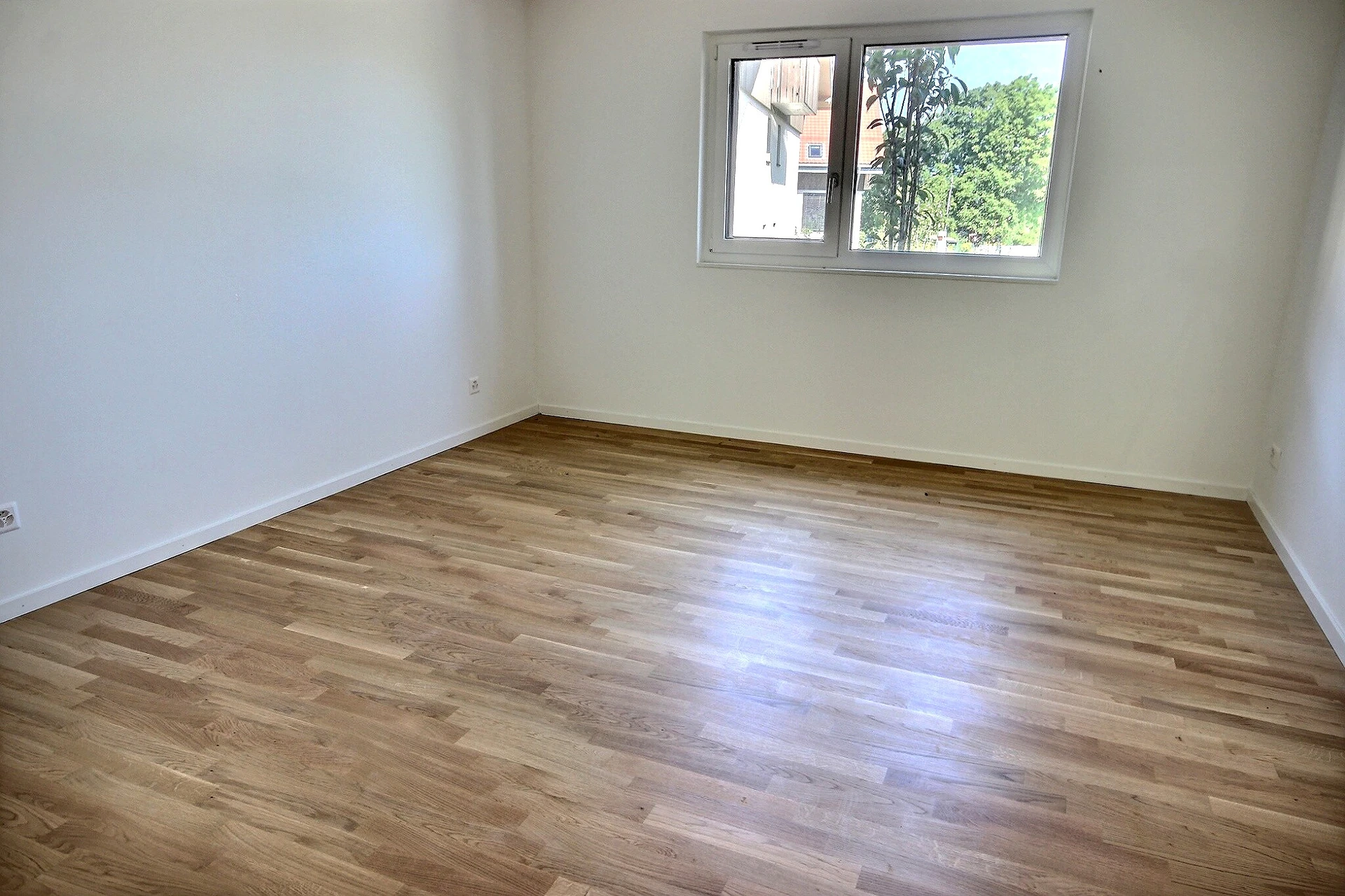 Leeres Zimmer mit Parkettboden und Fenster