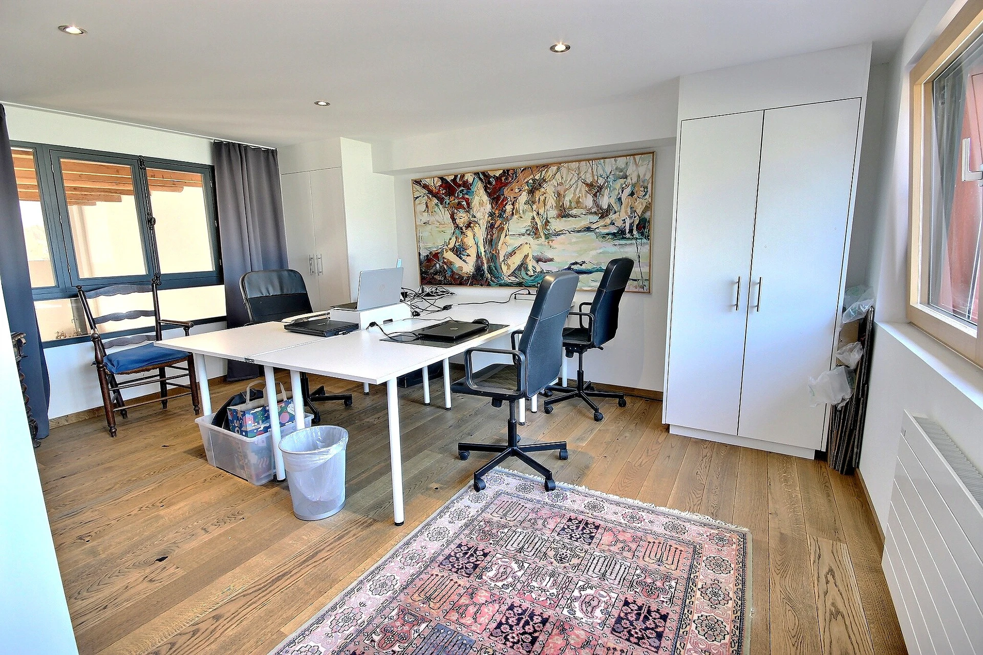Helles Arbeitszimmer mit Holzboden und Schreibtischen