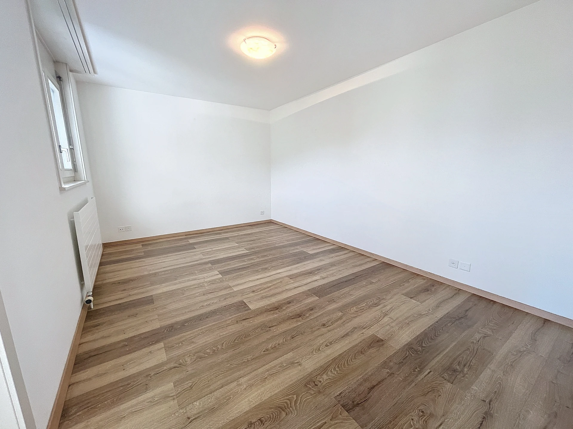 Leerer heller Raum mit Holzoptikboden