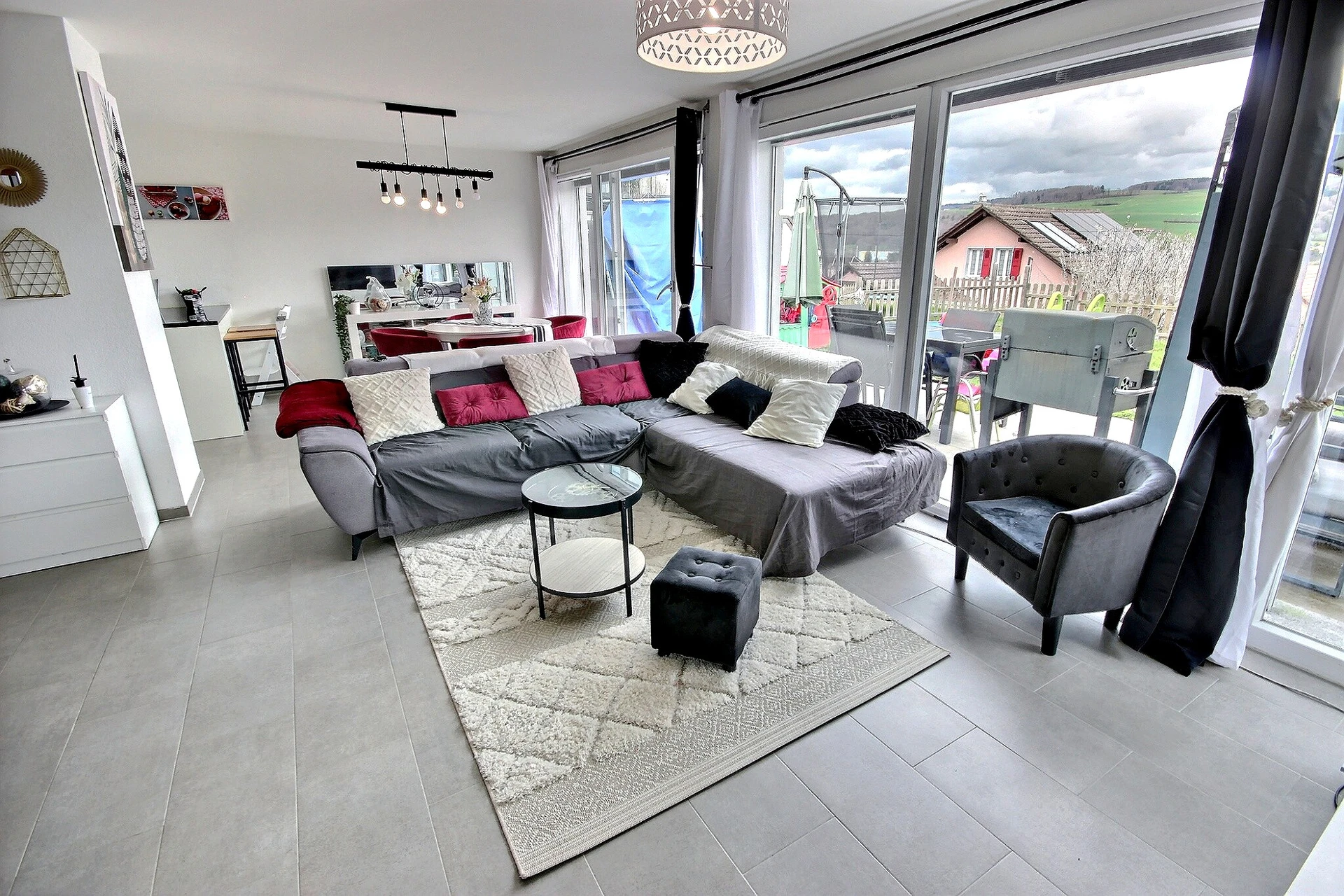 Heller Wohnbereich mit großer Fensterfront und Terrassenzugang