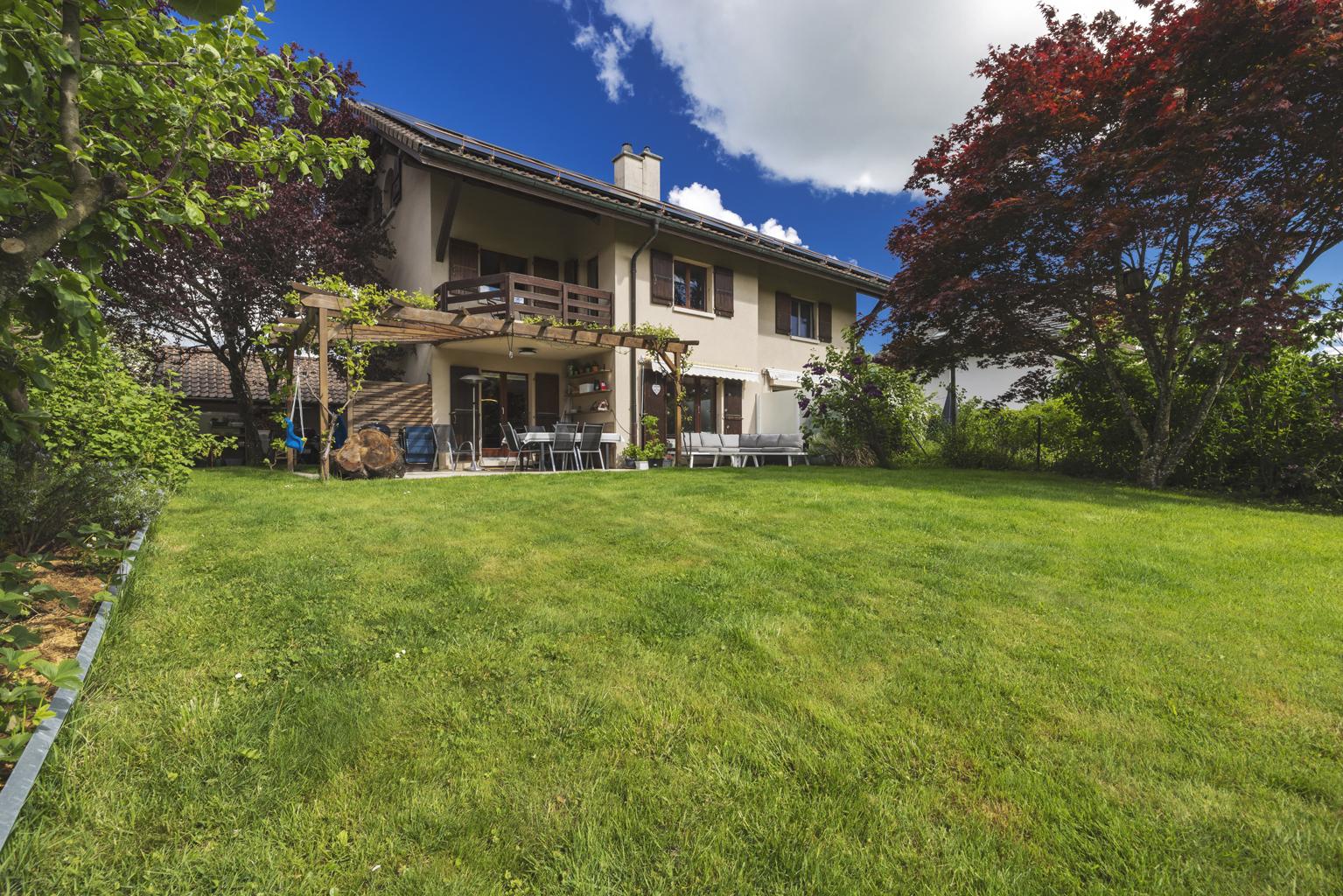 Gartenansicht eines Einfamilienhauses mit Terrasse