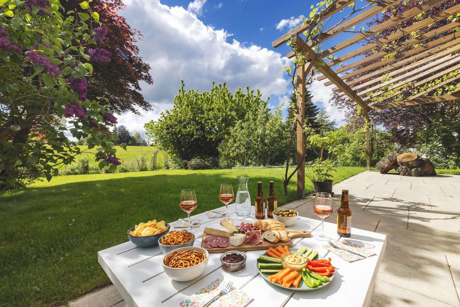 Garten mit Terrassensitzplatz und gedecktem Esstisch