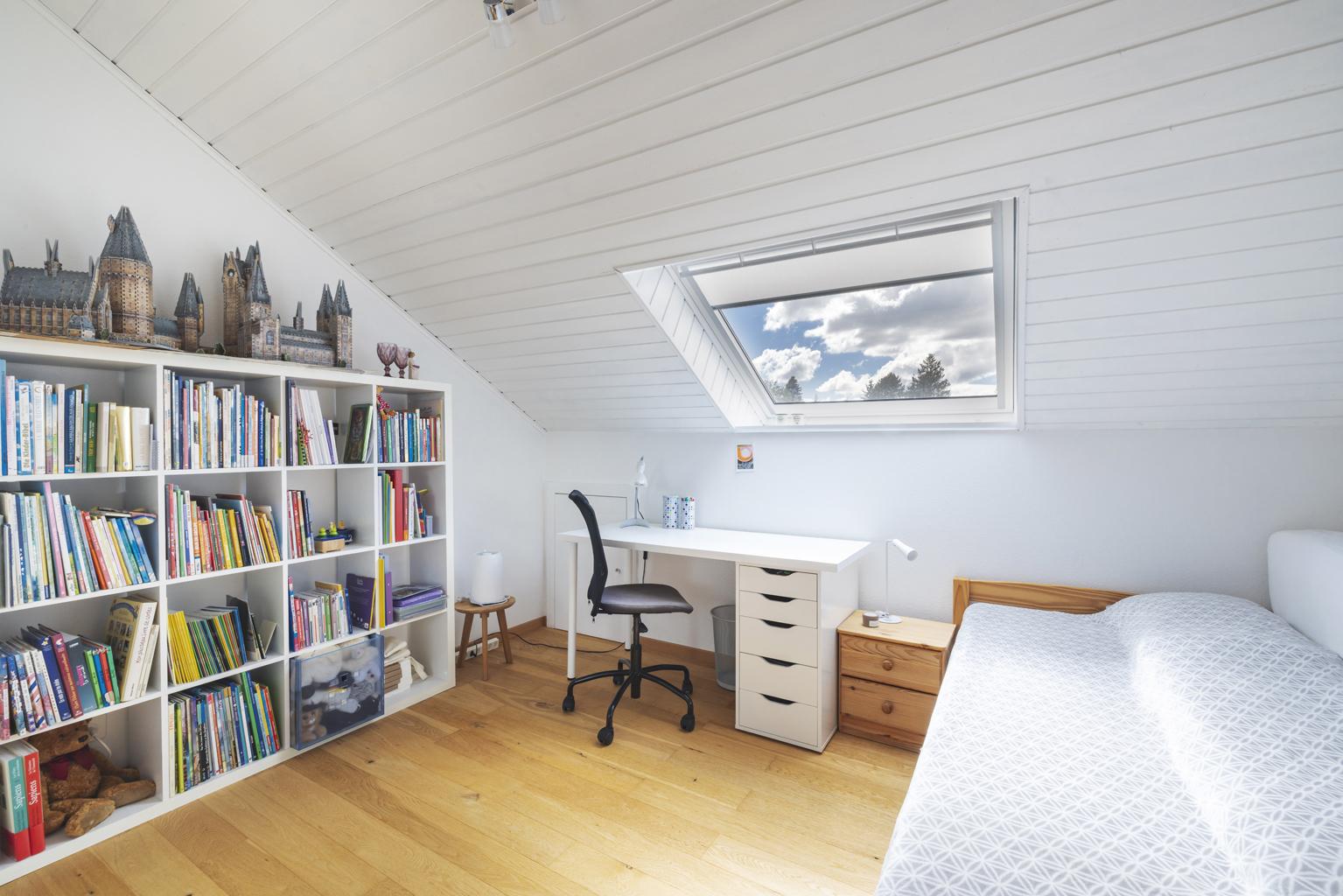 Dachzimmer mit Arbeitsplatz und Bett