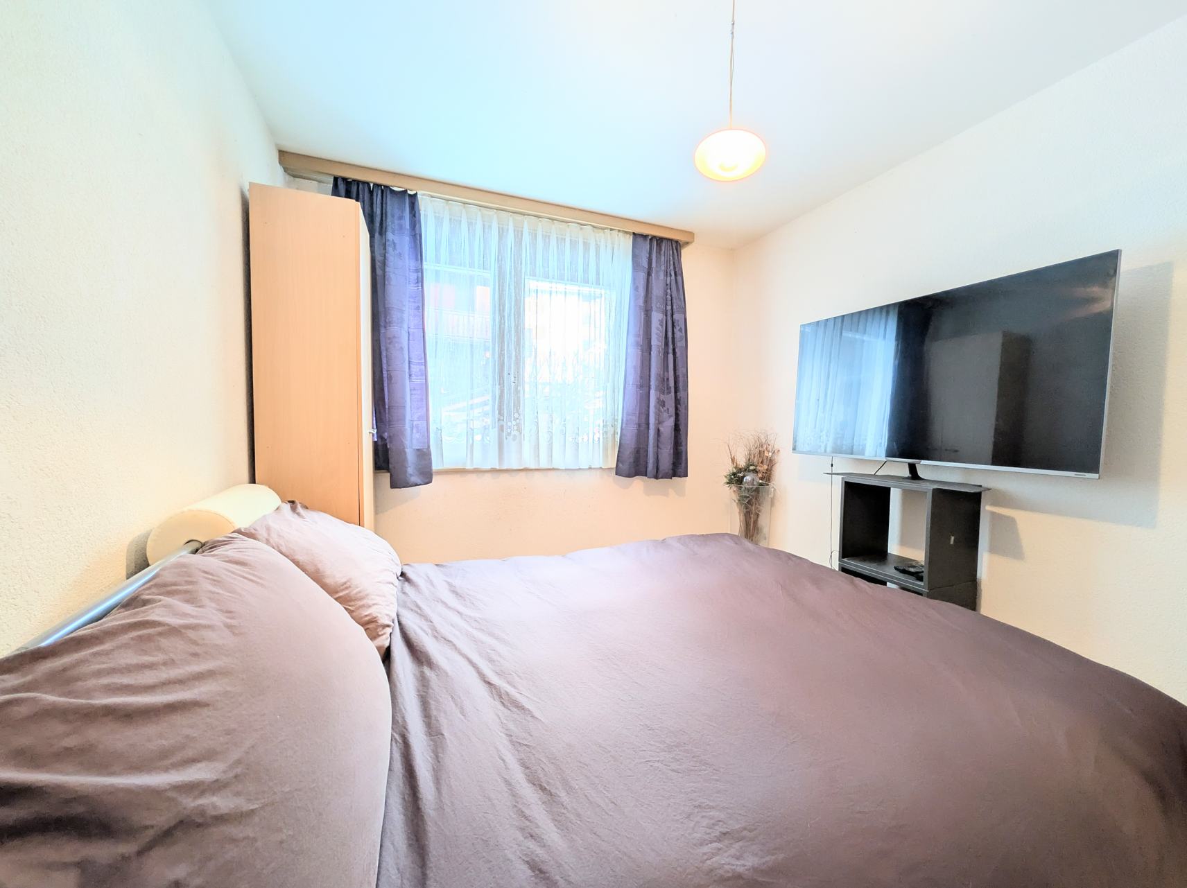 Schlafzimmer mit Bett und TV