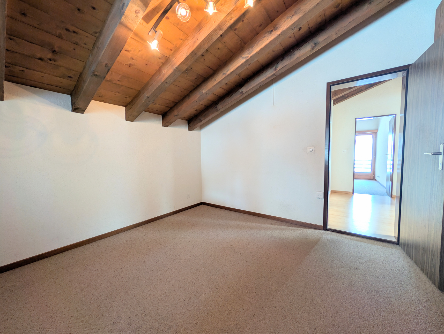 Dachzimmer mit sichtbaren Holzbalken