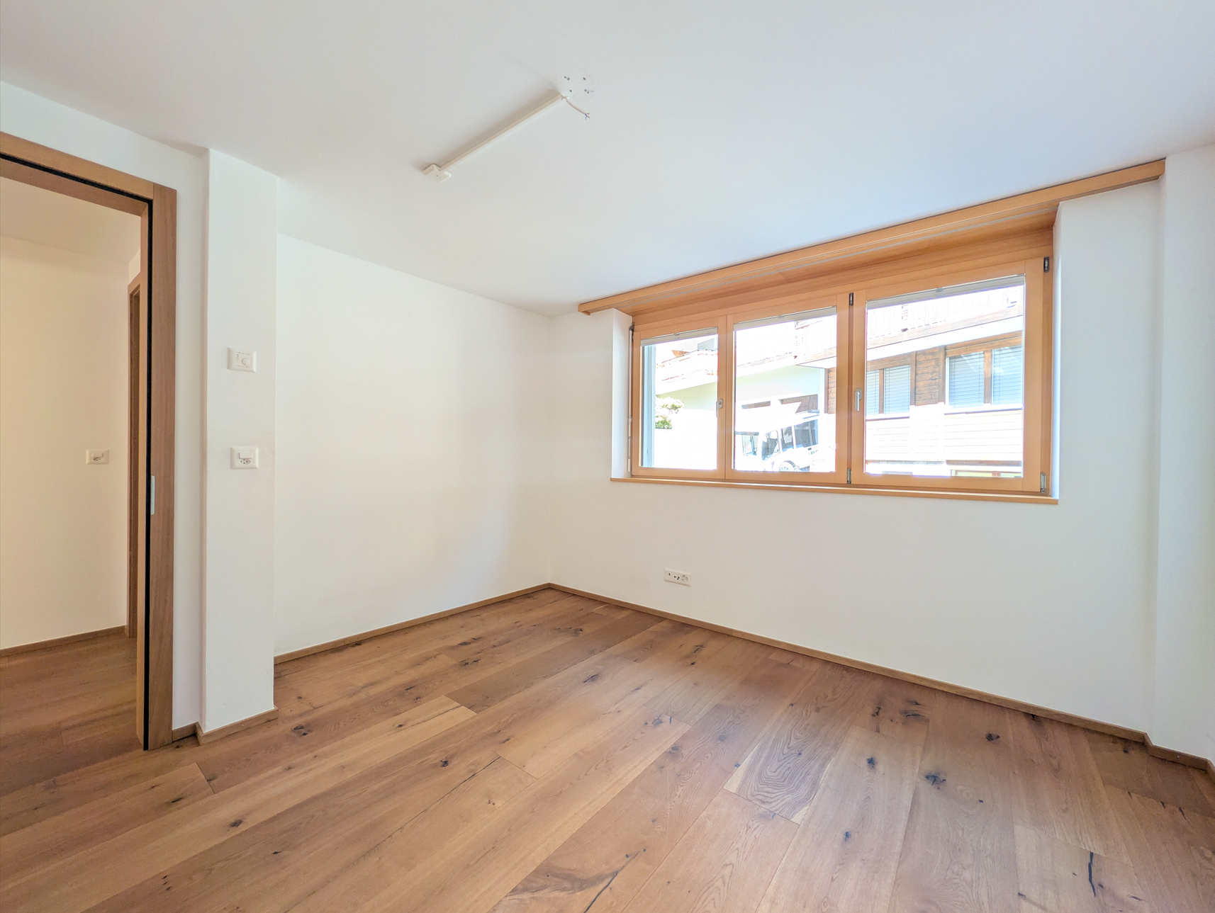 Leerer heller Raum mit Holzfenster und Parkettboden