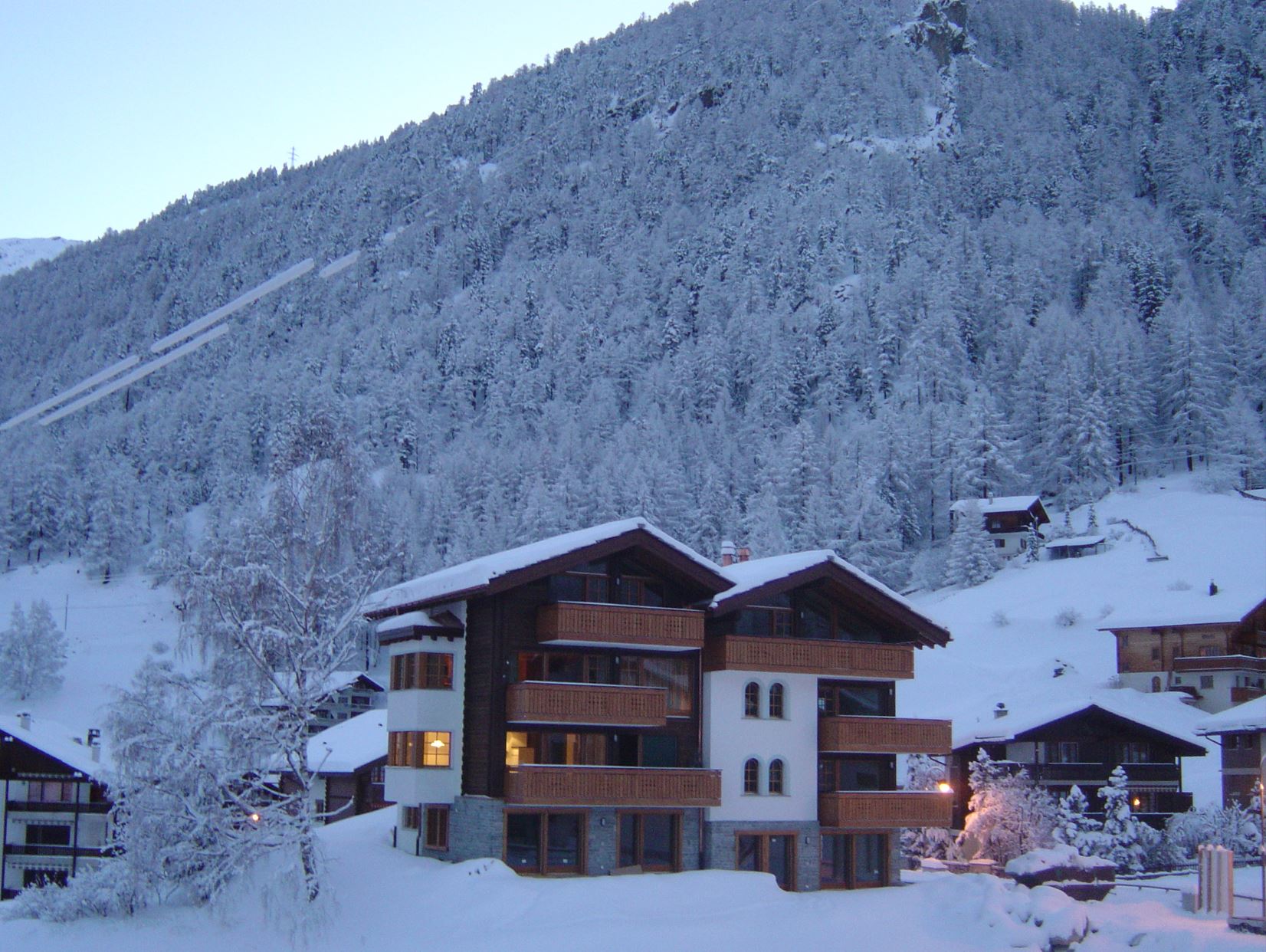 Verschneite Chaletanlage am Berghang