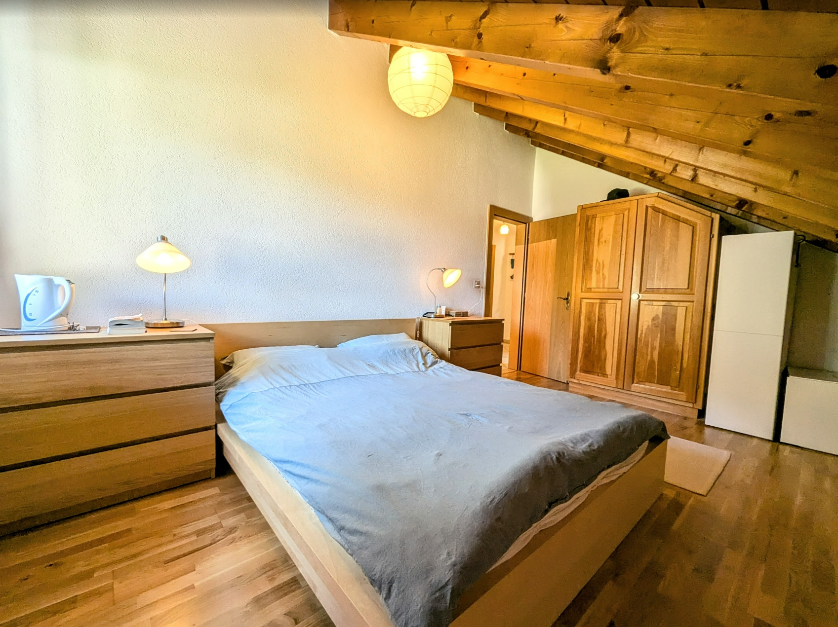 Gemütliches Schlafzimmer mit Holzmöbeln und Dachschräge