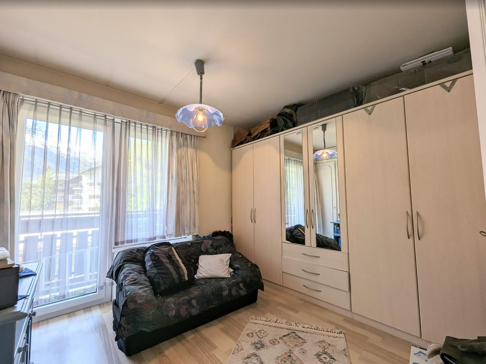 Schlafzimmer mit Balkonfenster und Kleiderschränken
