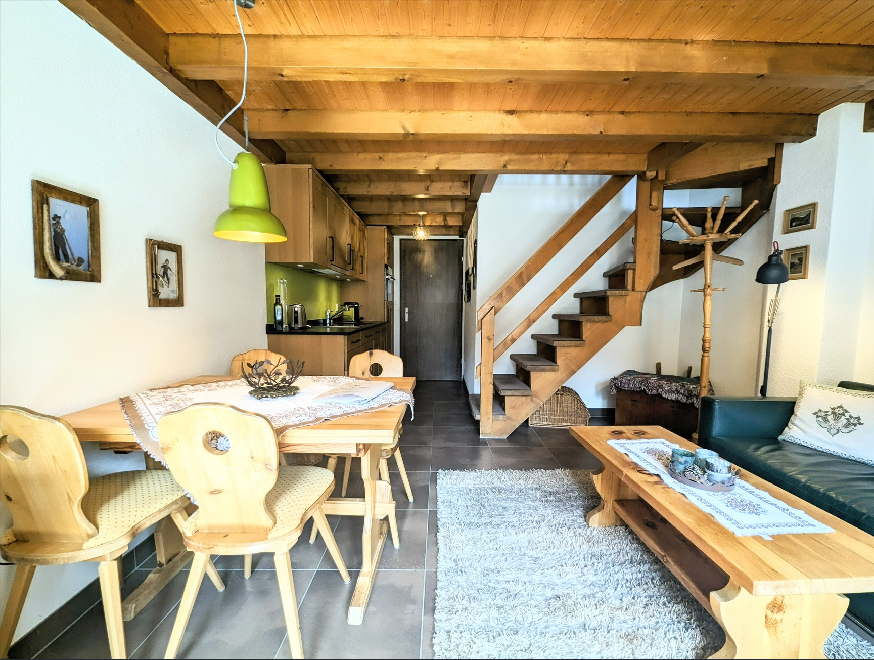 Gemütlicher Wohn-Essbereich mit offener Küche und Holztreppe
