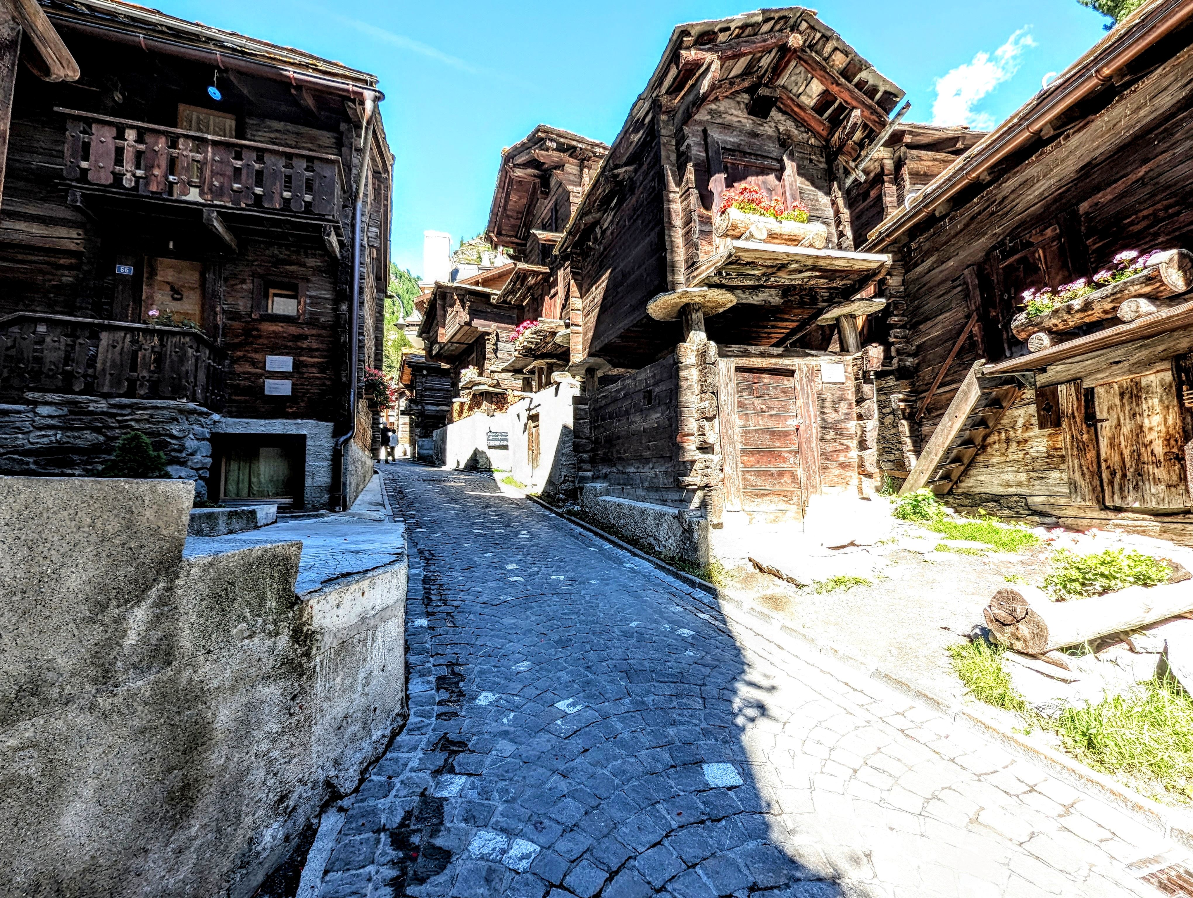 Alpine Dorfstraße mit traditionellen Holzhäusern