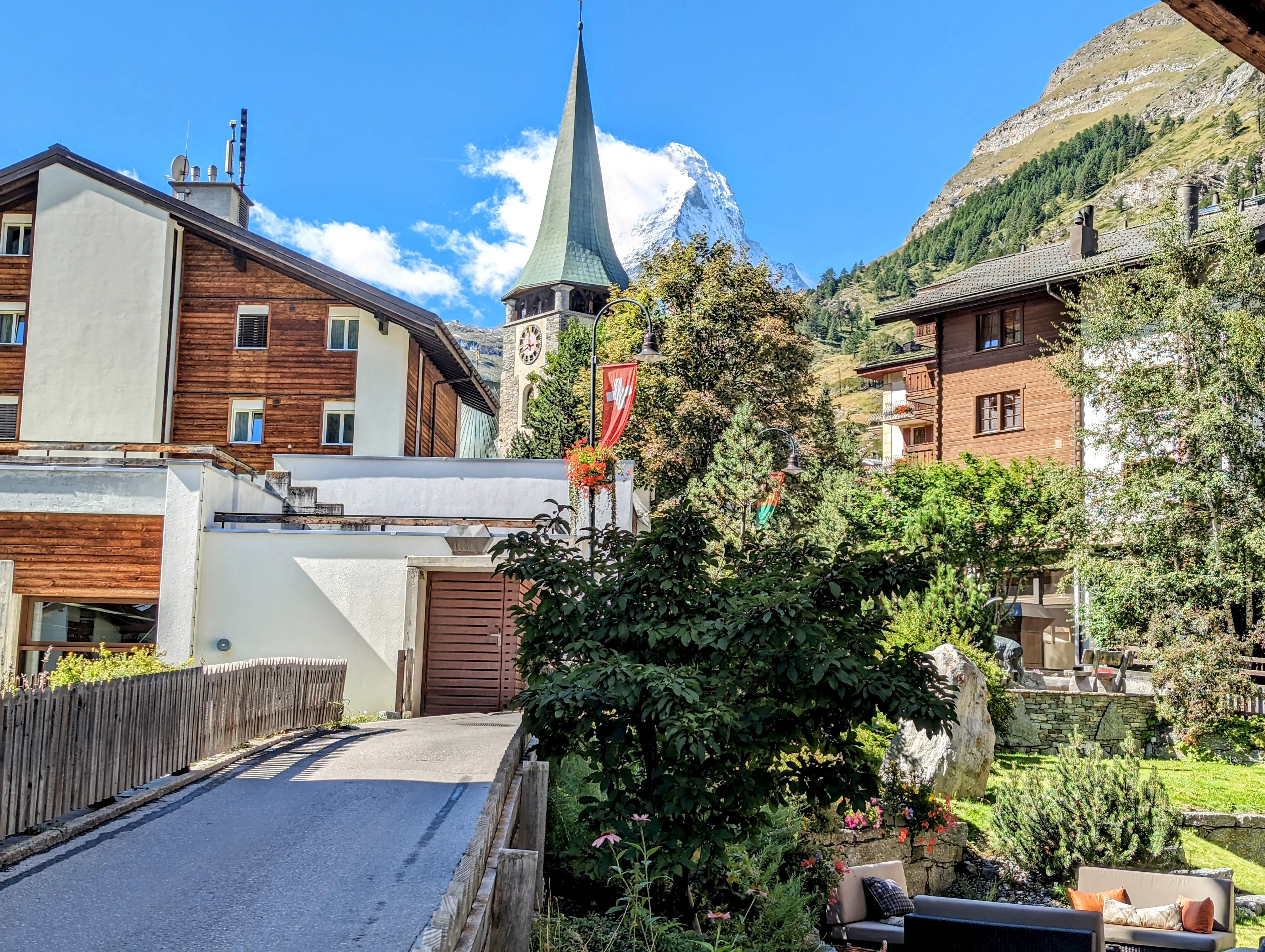 Alpine Dorfansicht mit Kirche und Bergpanorama