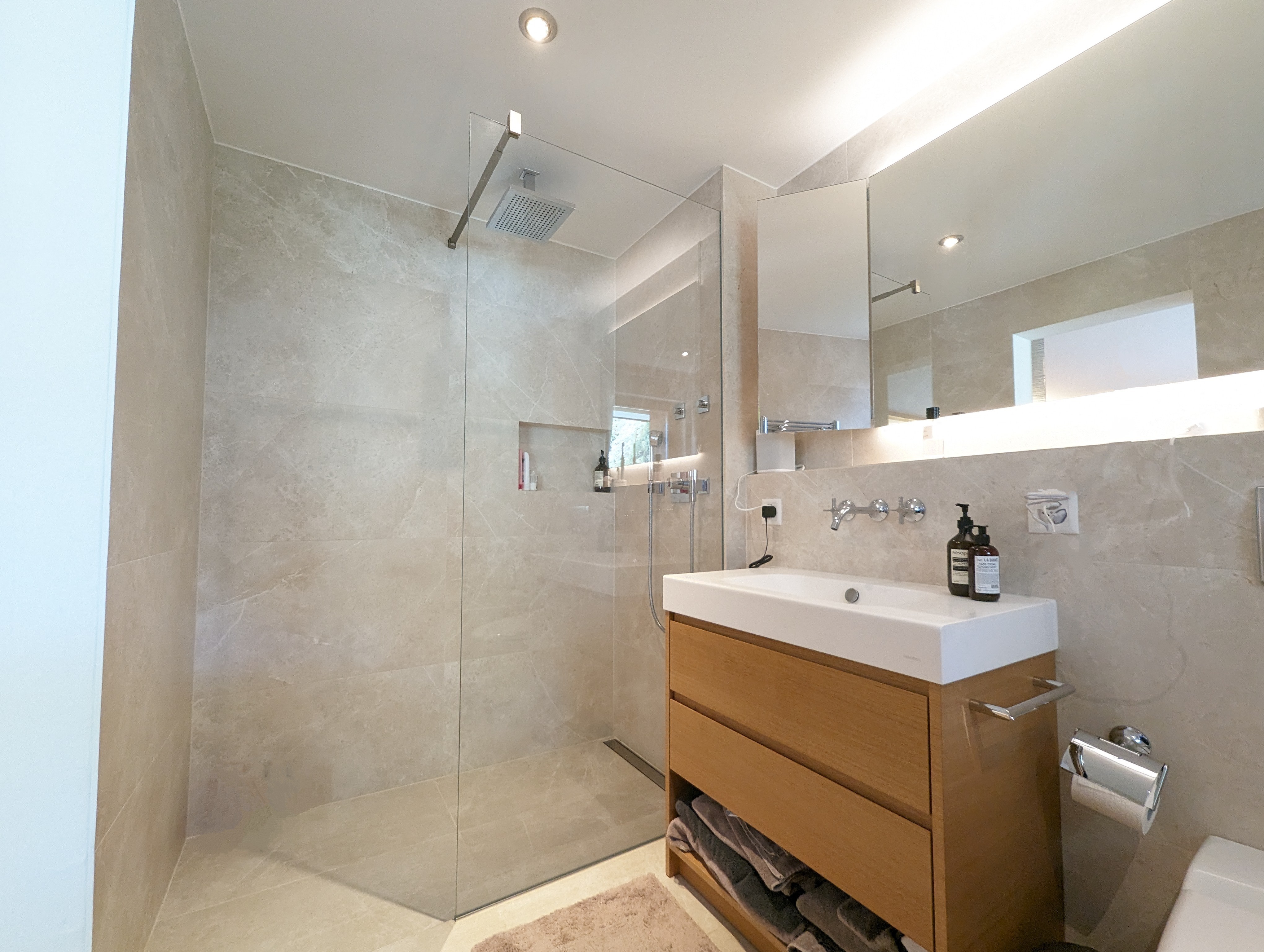 Modernes Badezimmer mit begehbarer Dusche und Holzwaschtisch