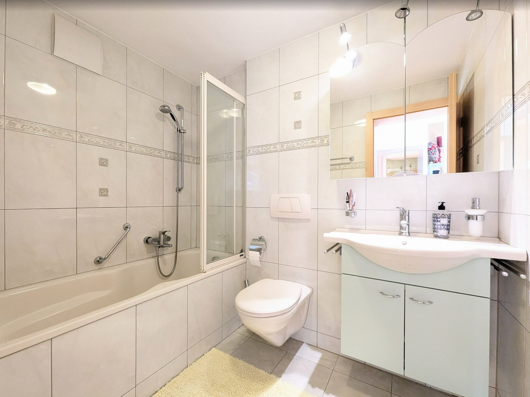 Helles Badezimmer mit Badewanne, Dusche und Waschtisch