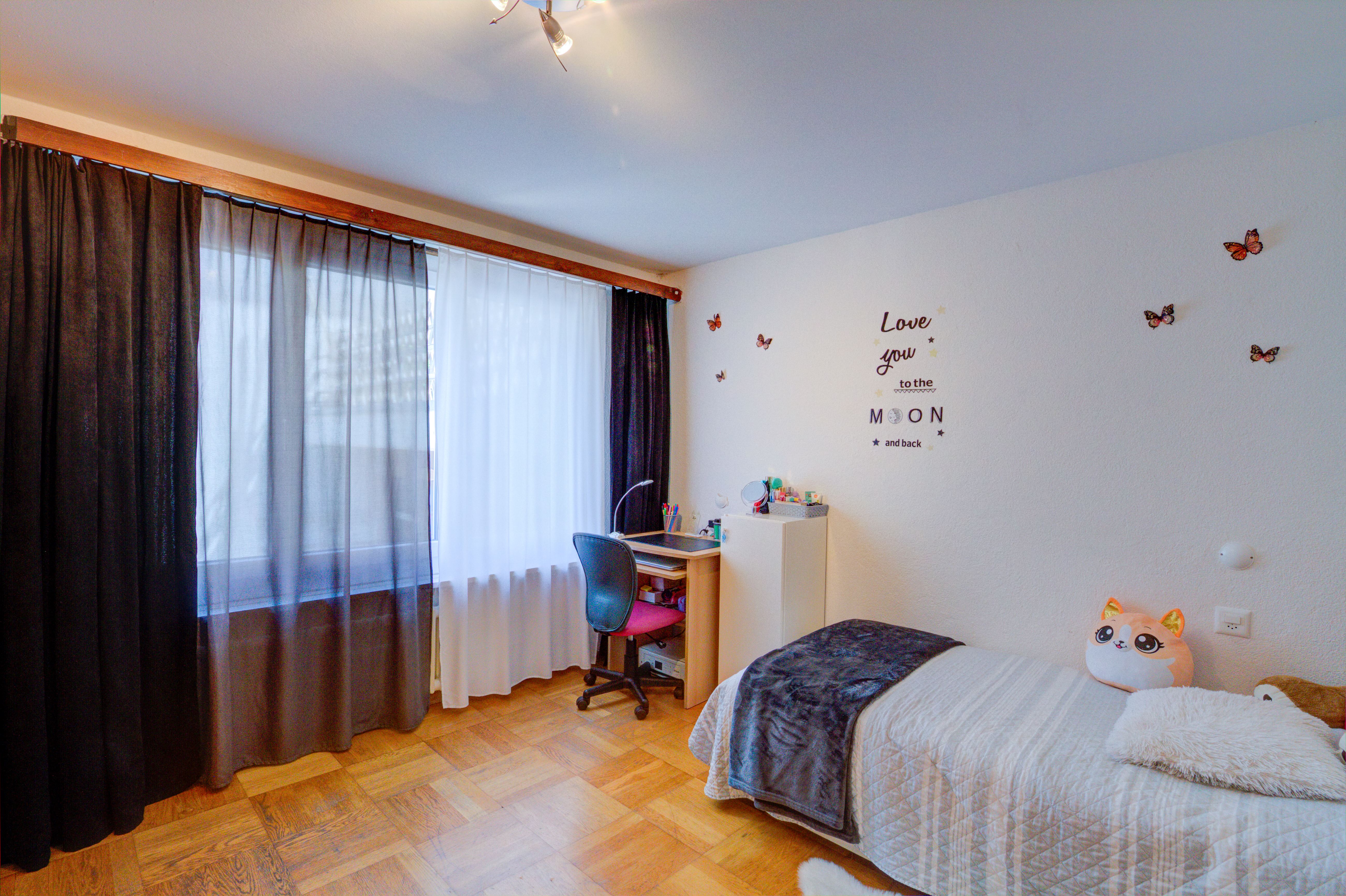 Jugendzimmer mit Bett und Arbeitsbereich