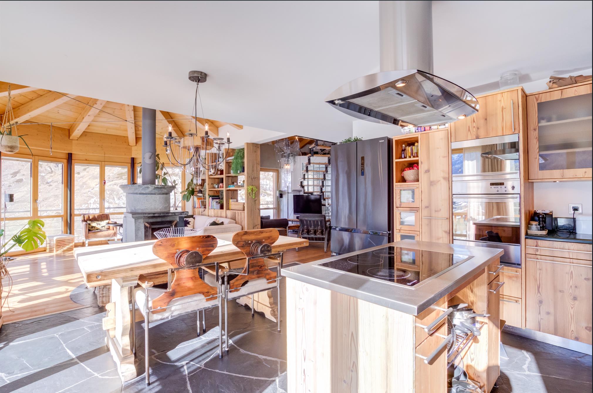 Offene Wohnküche mit Holz und Kamin