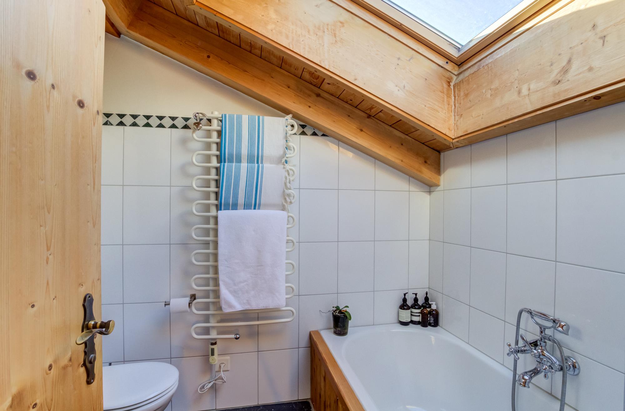 Dachbad mit Badewanne und Holzschräge