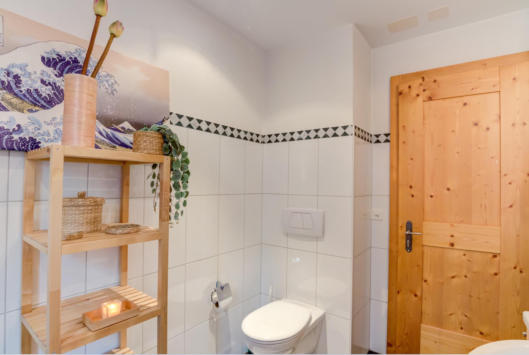 Helles Gäste-WC mit Holztür und offener Holzablage