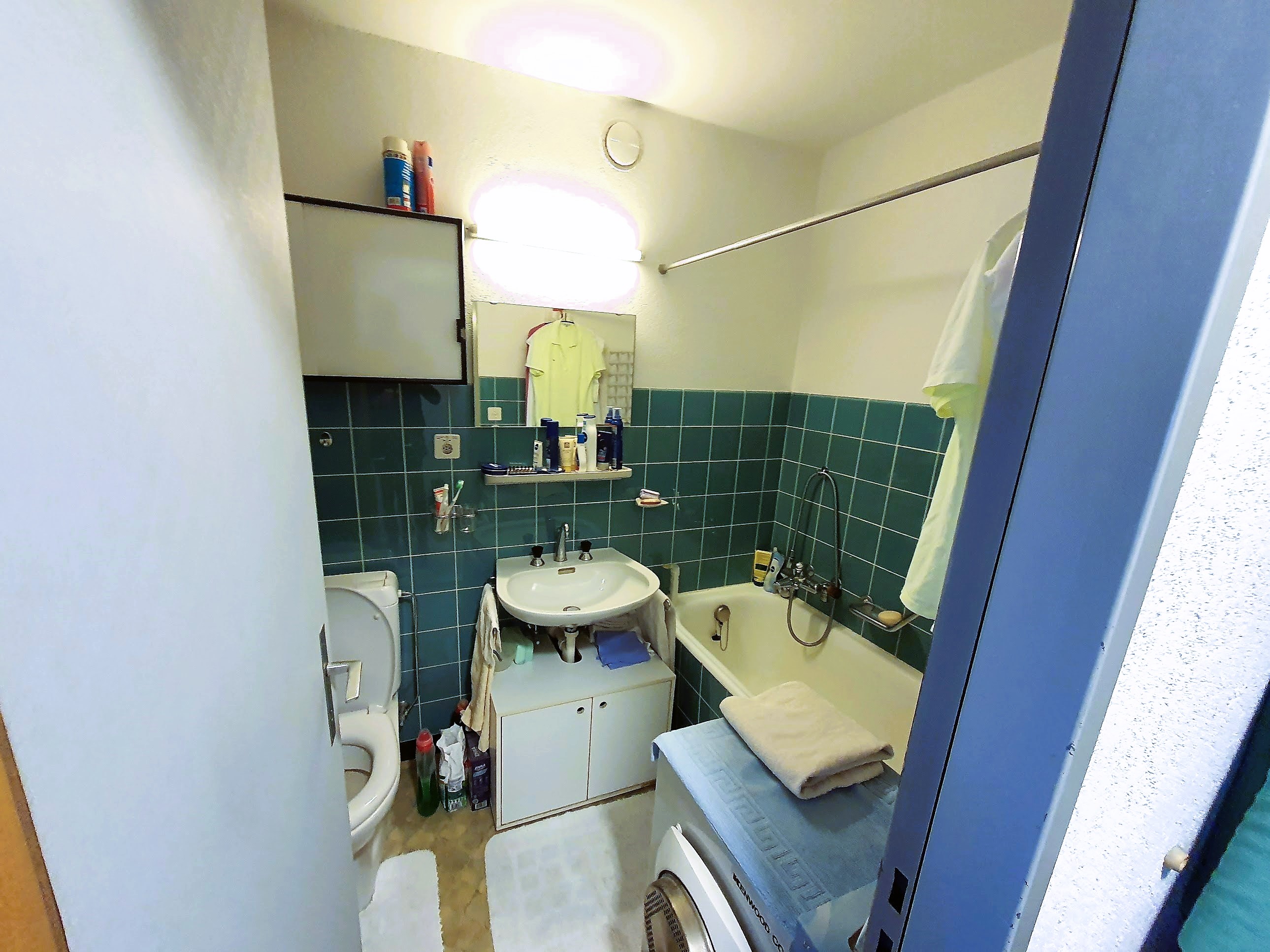 Kleines, einfaches Badezimmer mit Wanne und WC