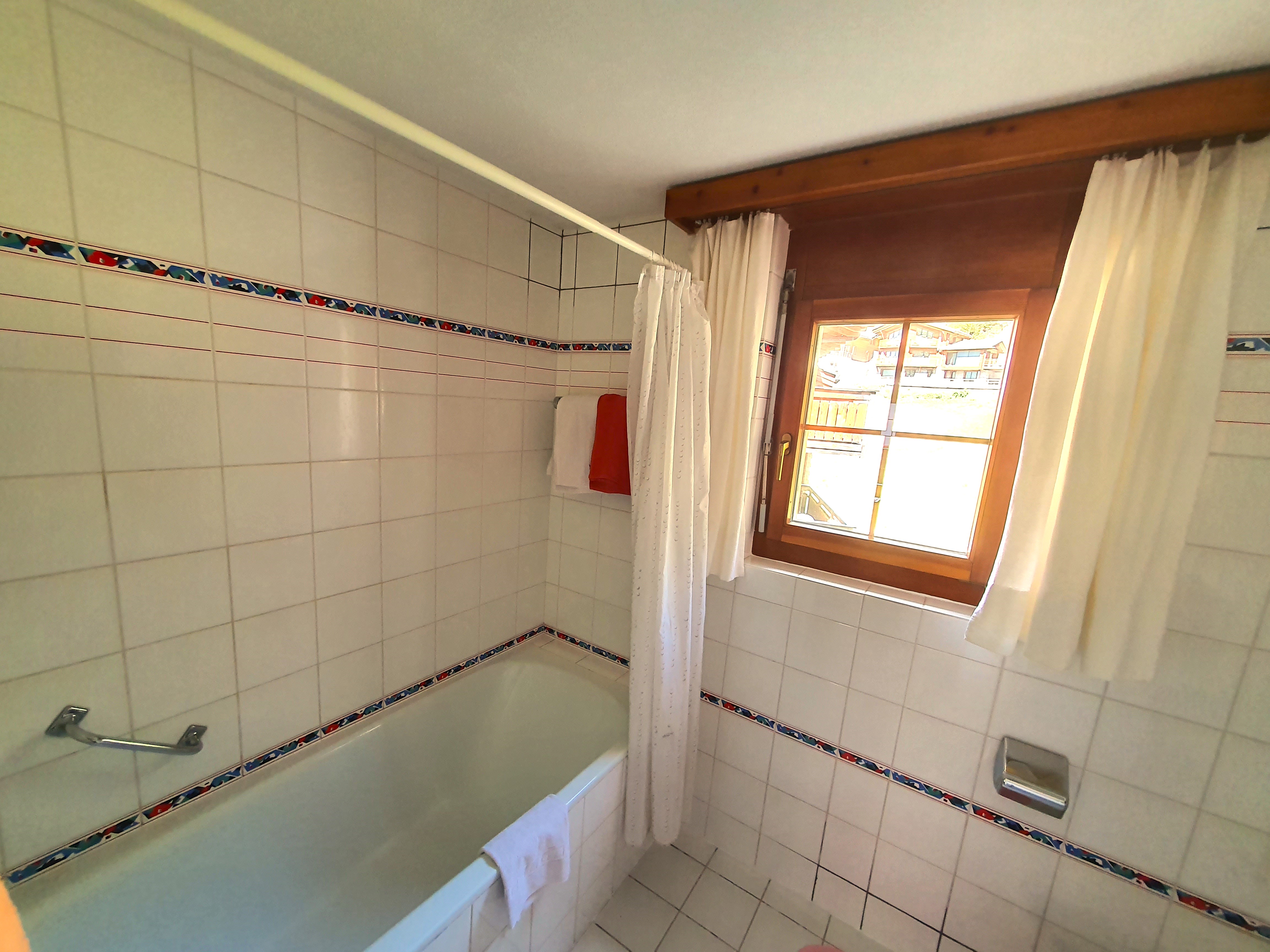 Badezimmer mit Badewanne und Fenster