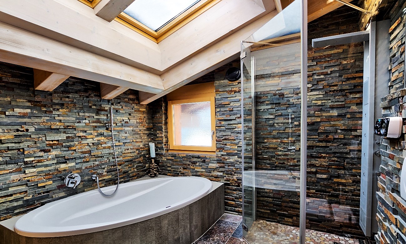 Luxuriöses Badezimmer mit Naturstein und Badewanne