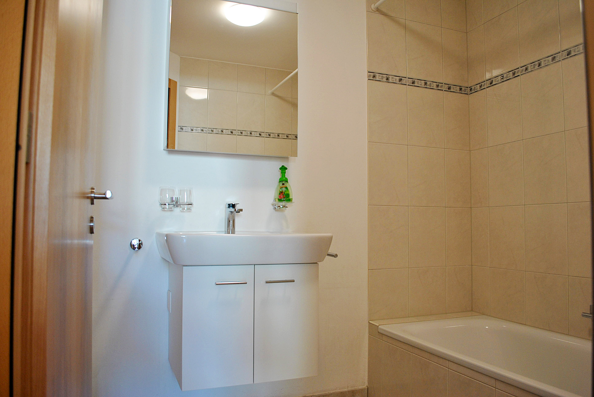 Kleines Badezimmer mit Badewanne und Waschtisch