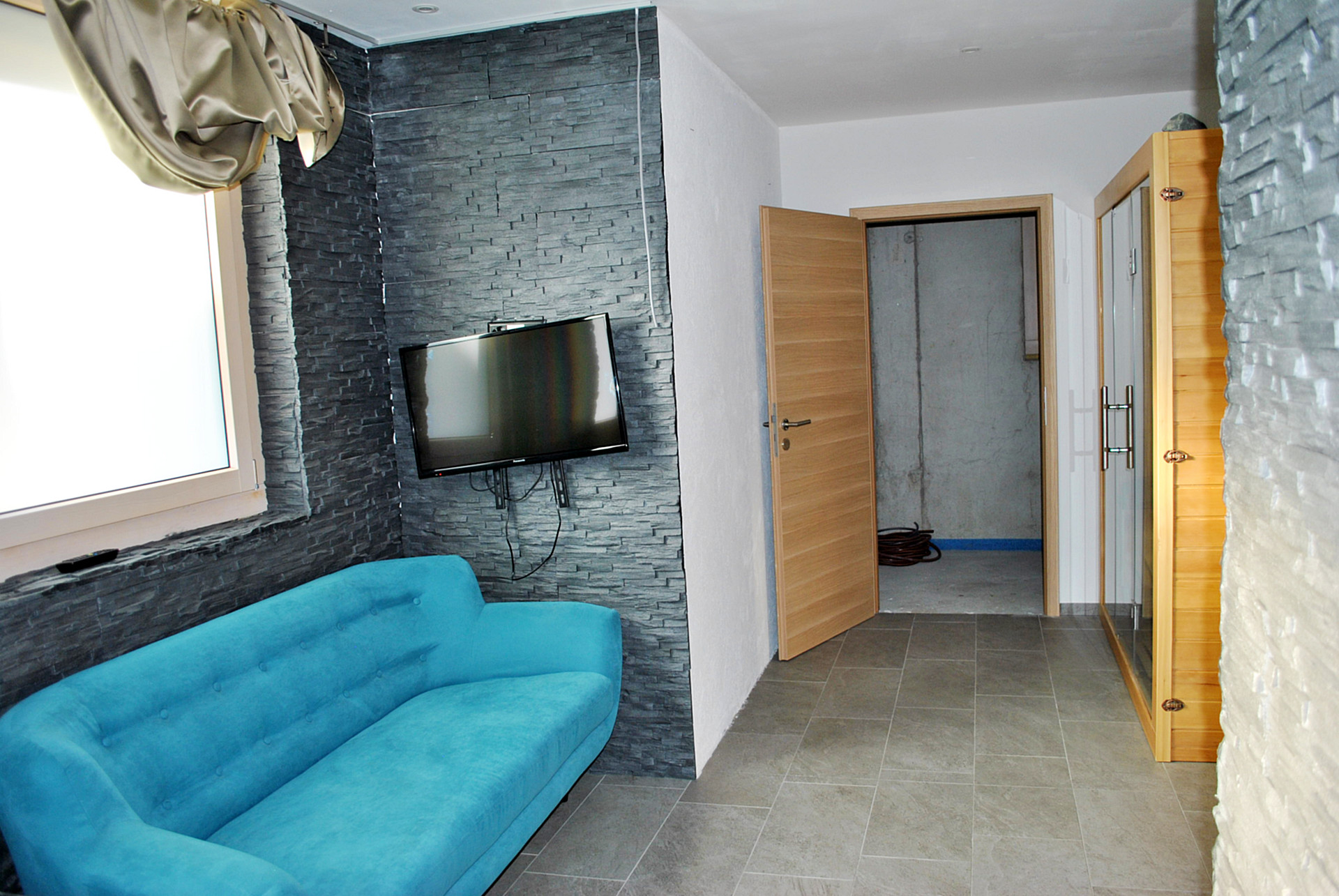 Modernes Wohnzimmer mit TV und blauem Sofa