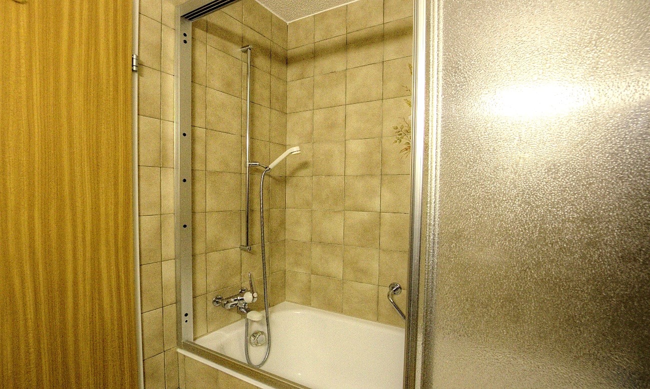 Badezimmer mit Badewanne und Duschbereich