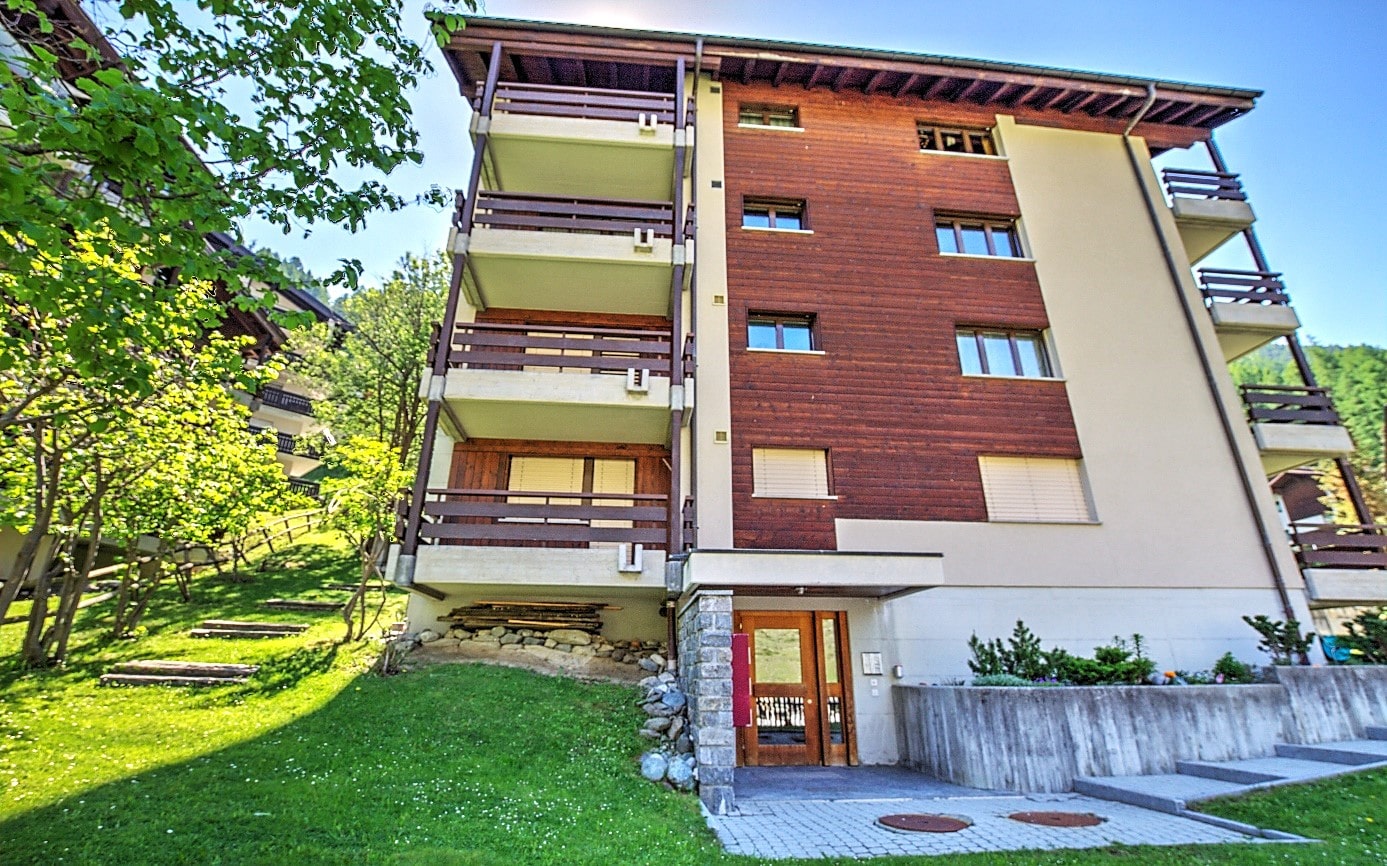 Mehrfamilienhaus mit Holzfassade und Balkonen