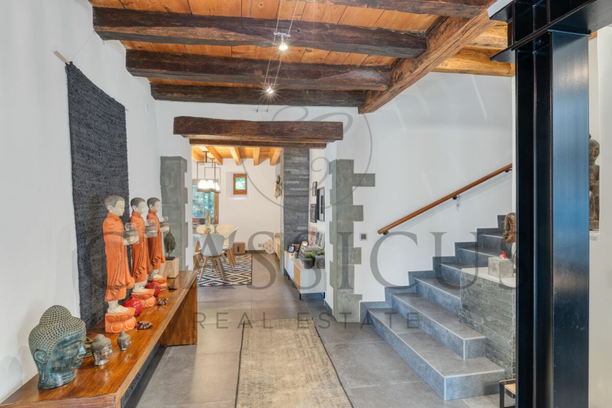 Rustikaler Eingangsflur mit Treppe und Kunstobjekten