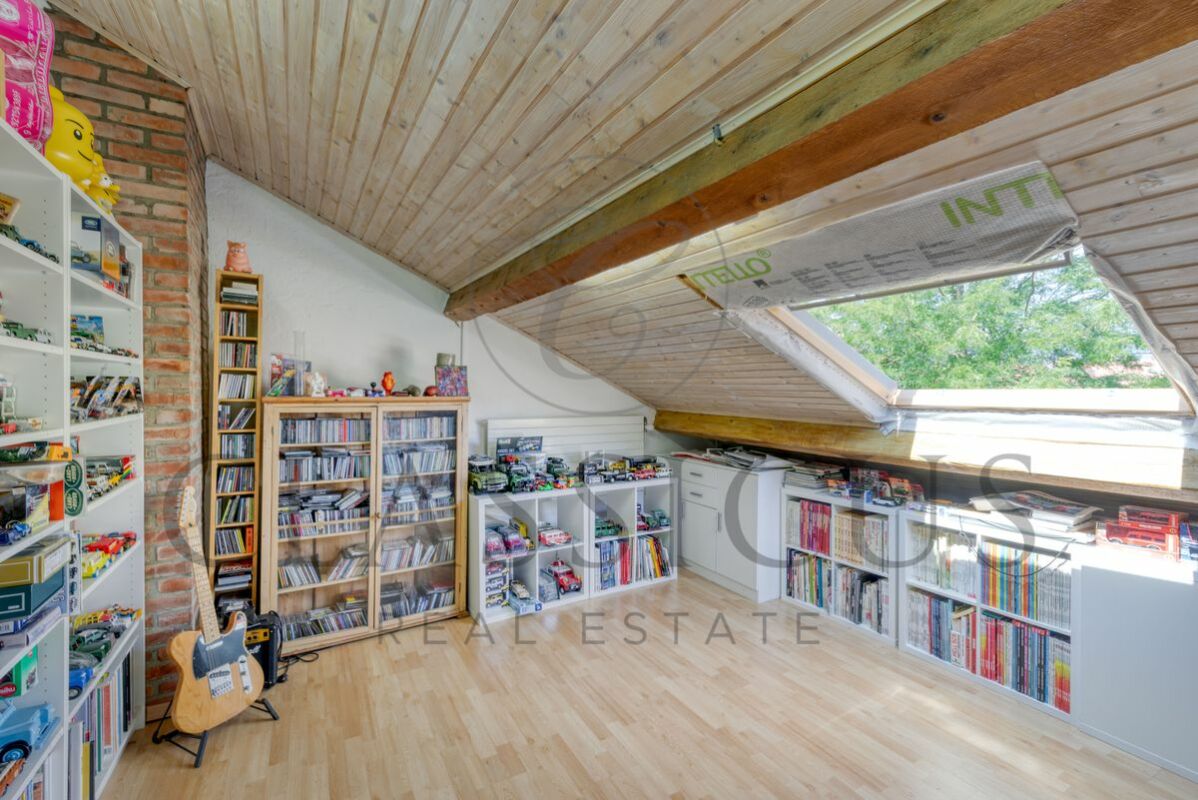 Dachzimmer mit Holzdecke und Sammlungsregalen
