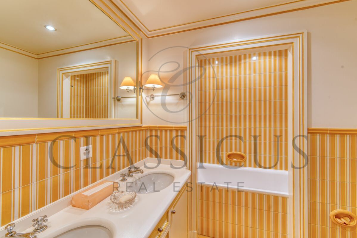 Badezimmer mit gelb-weiß gestreiften Fliesen