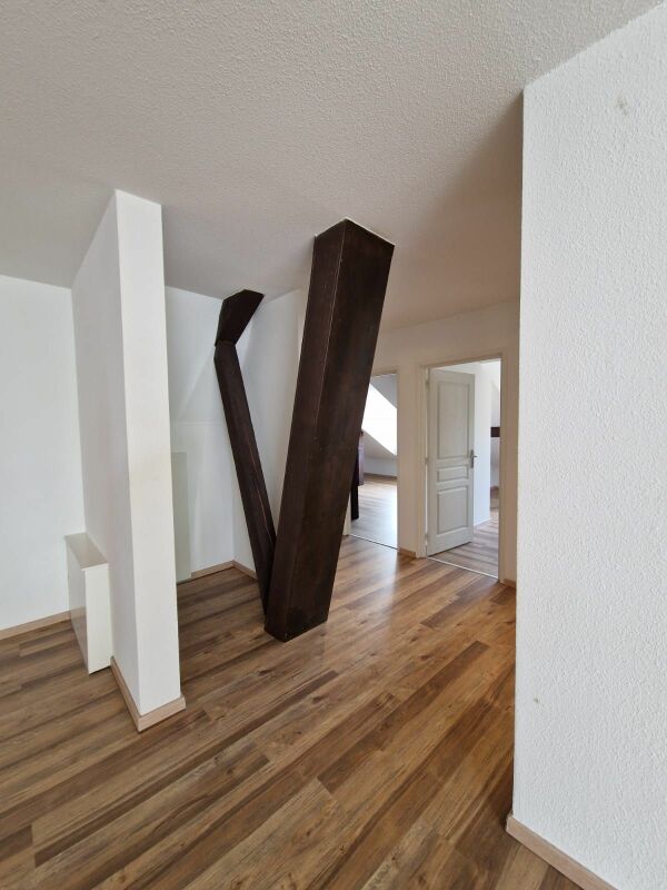 Heller Flur mit Holzoptikboden und markanten Stützen