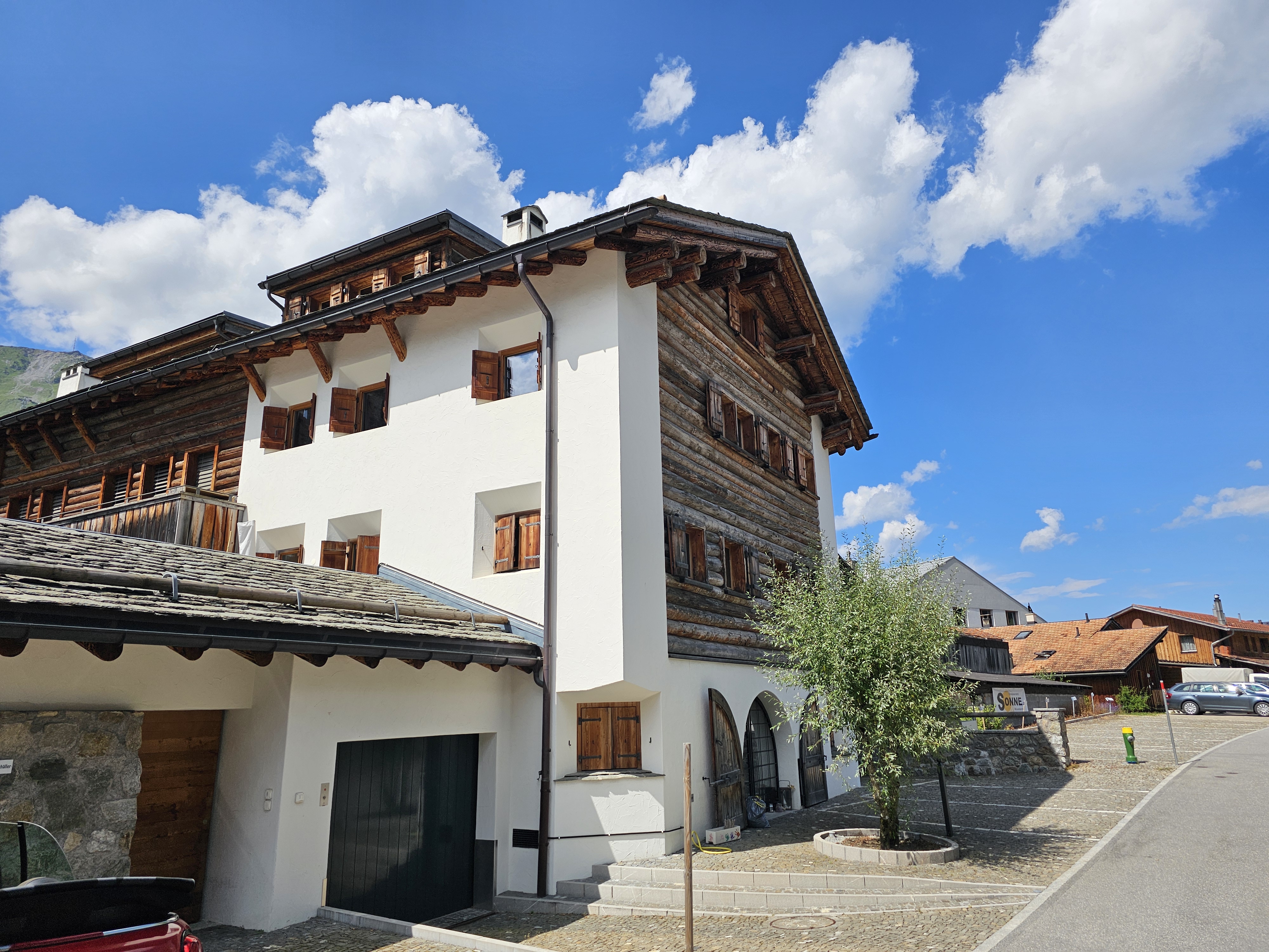Alpines Wohnhaus mit Holzfassade und weißem Putz