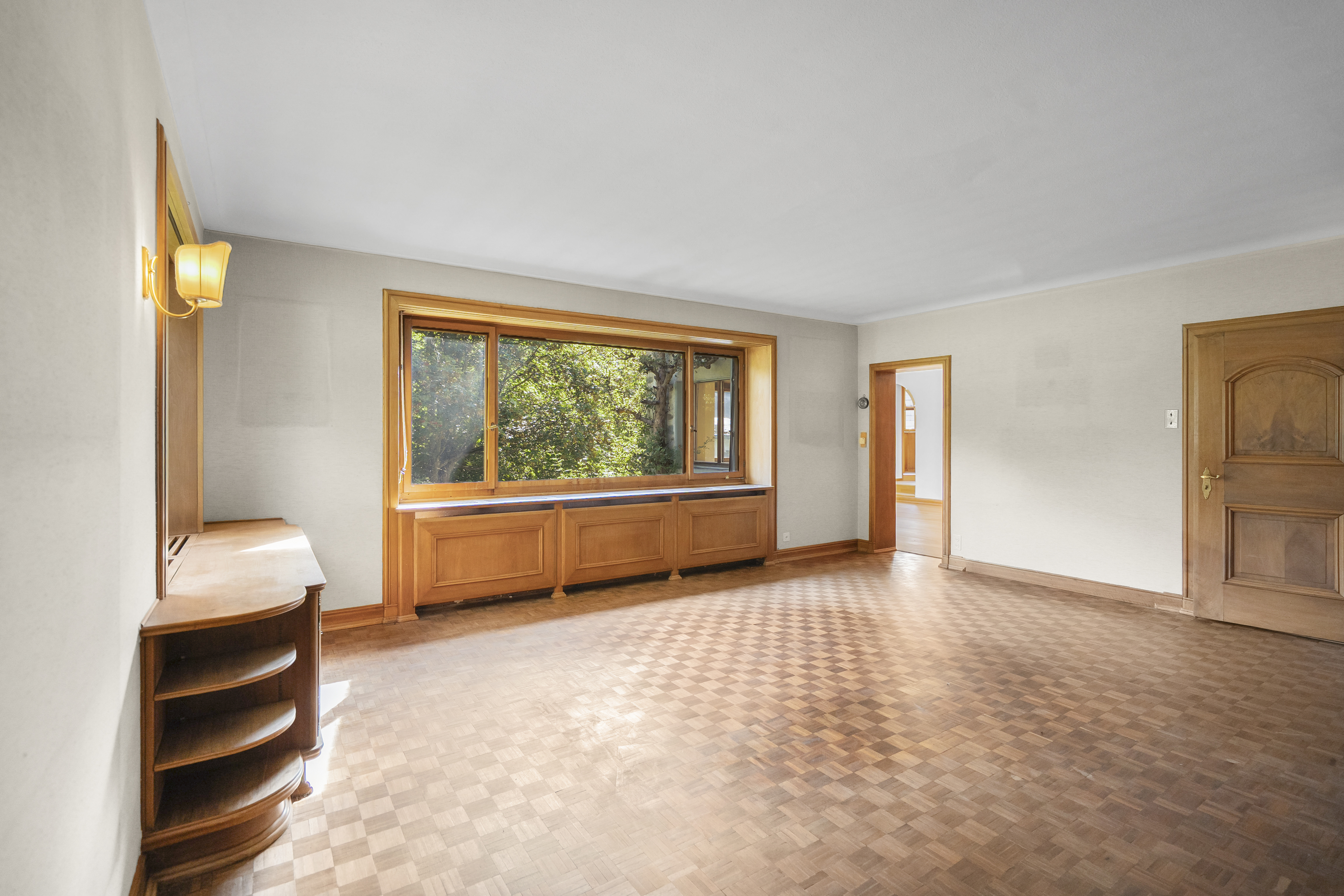 Großer leerer Wohnraum mit Holzfenstern