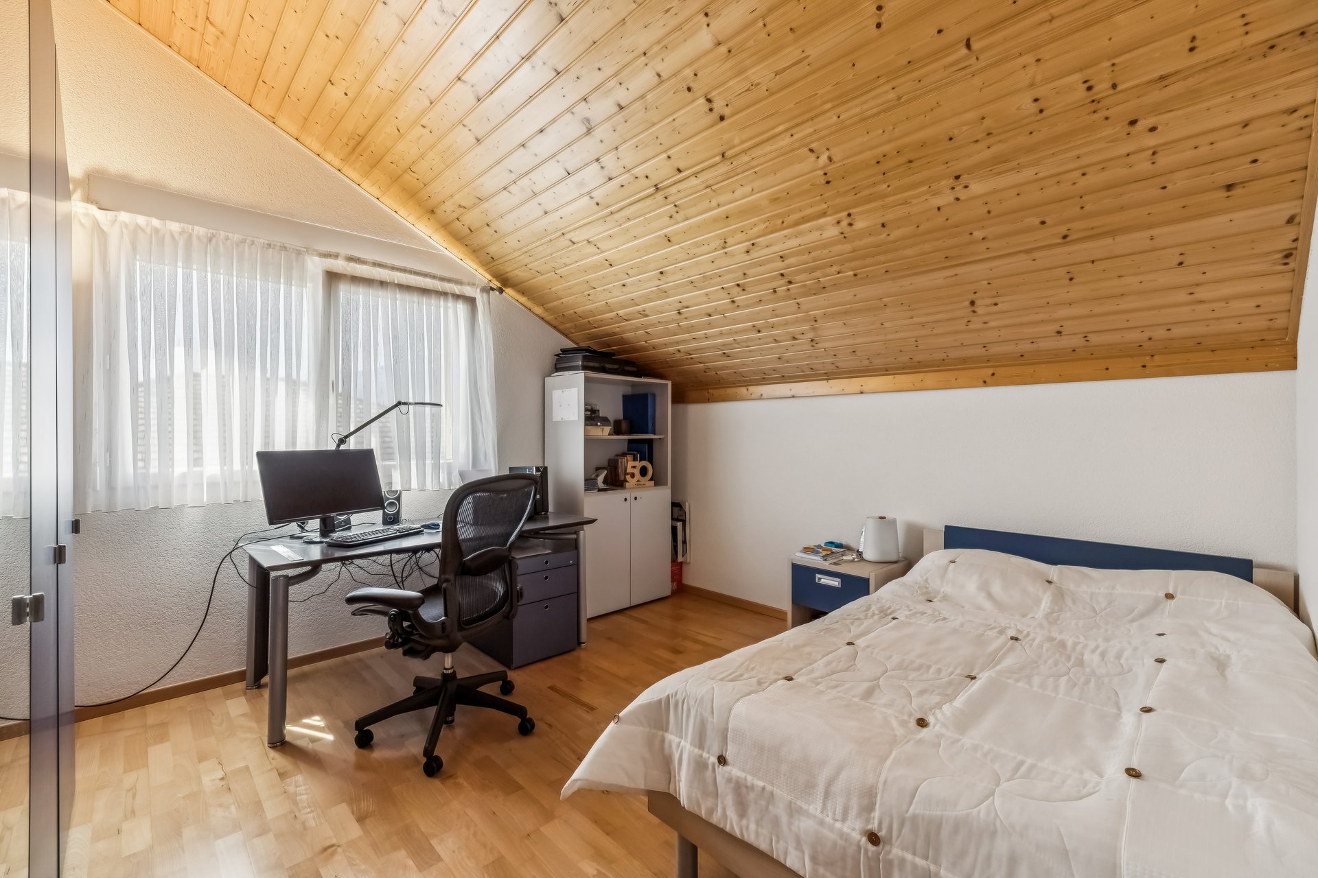 Schlafzimmer mit Arbeitsbereich im Dachgeschoss