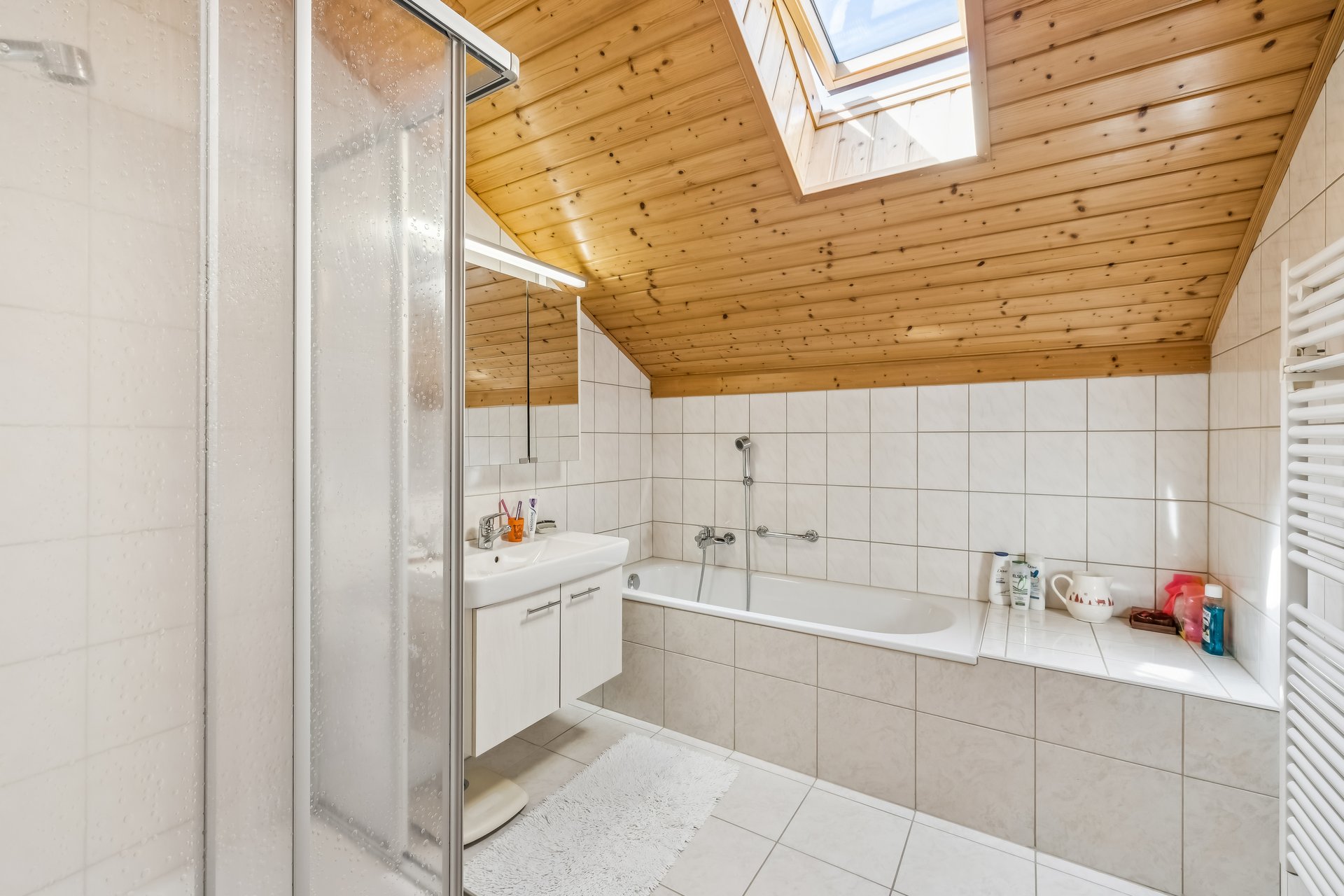 Helles Dachgeschoss-Badezimmer mit Badewanne und Dusche