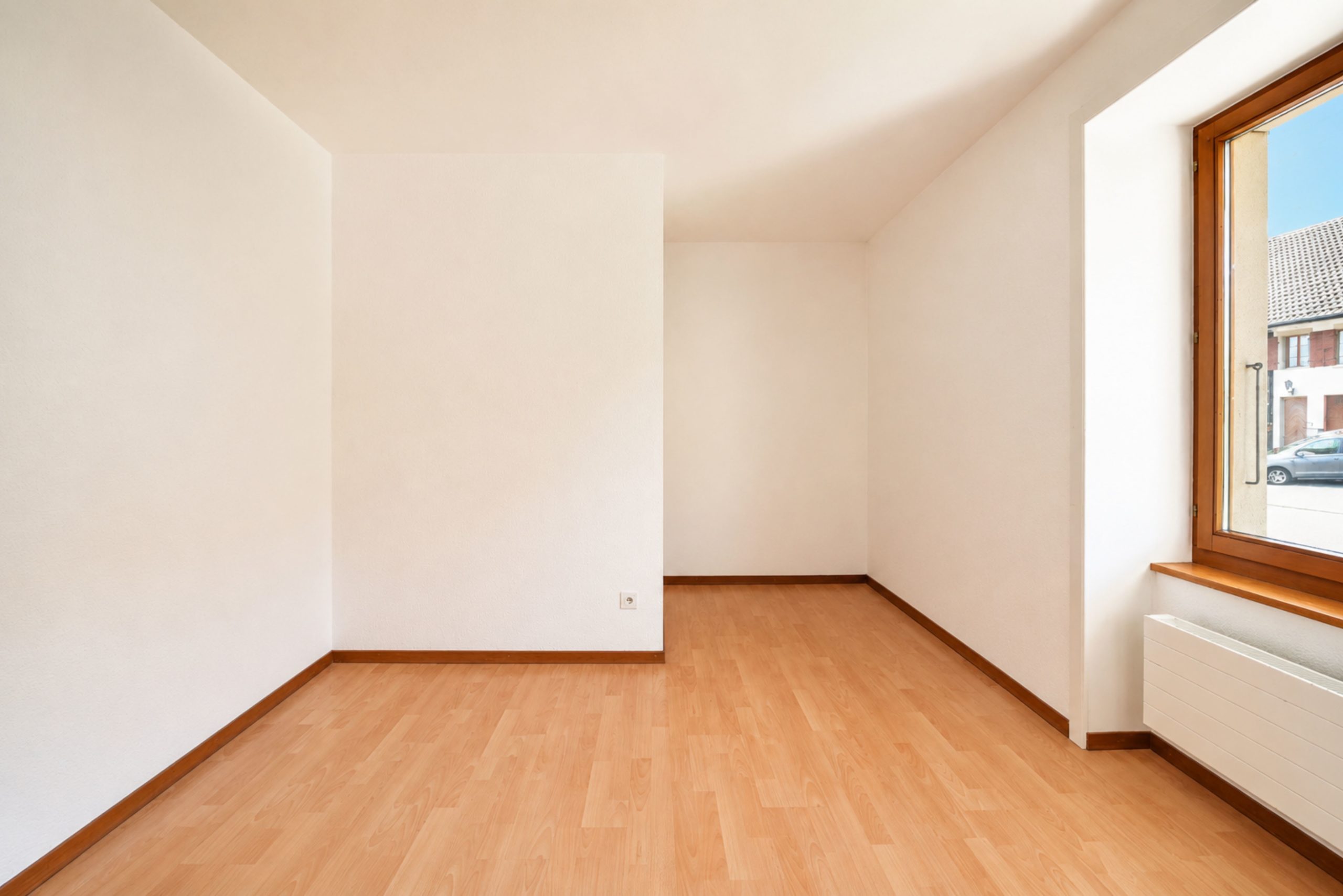 Leerer, heller Dachraum mit Holzfenster