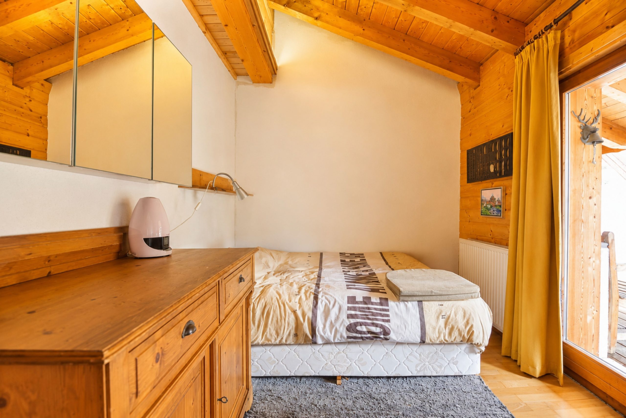 Gemütliches Schlafzimmer mit Holzvertäfelung