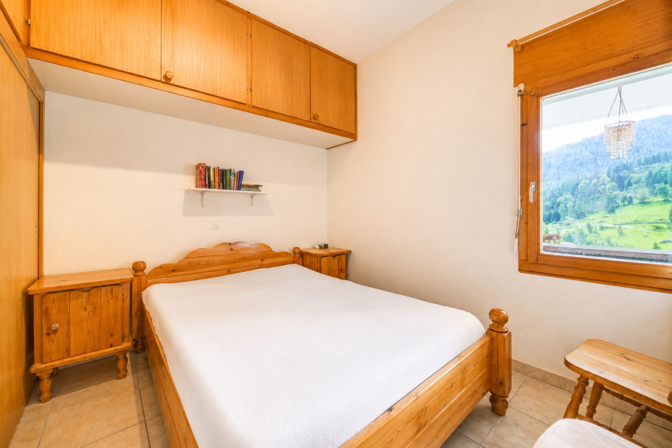 Gemütliches Schlafzimmer mit Holzmöbeln und Bergblick