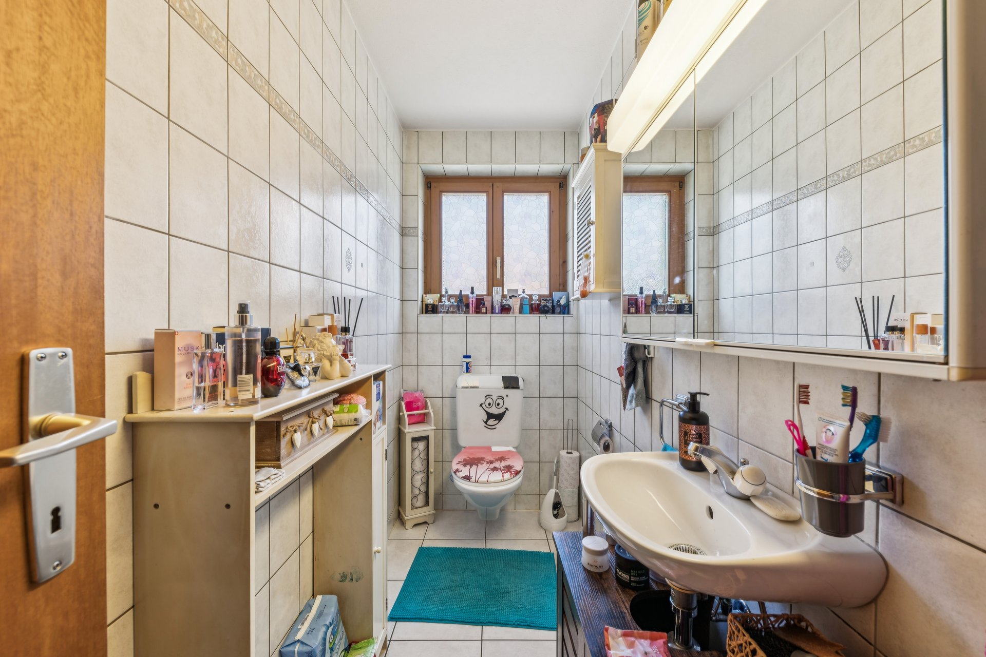 Kleines gefliestes Badezimmer mit WC und Waschbecken