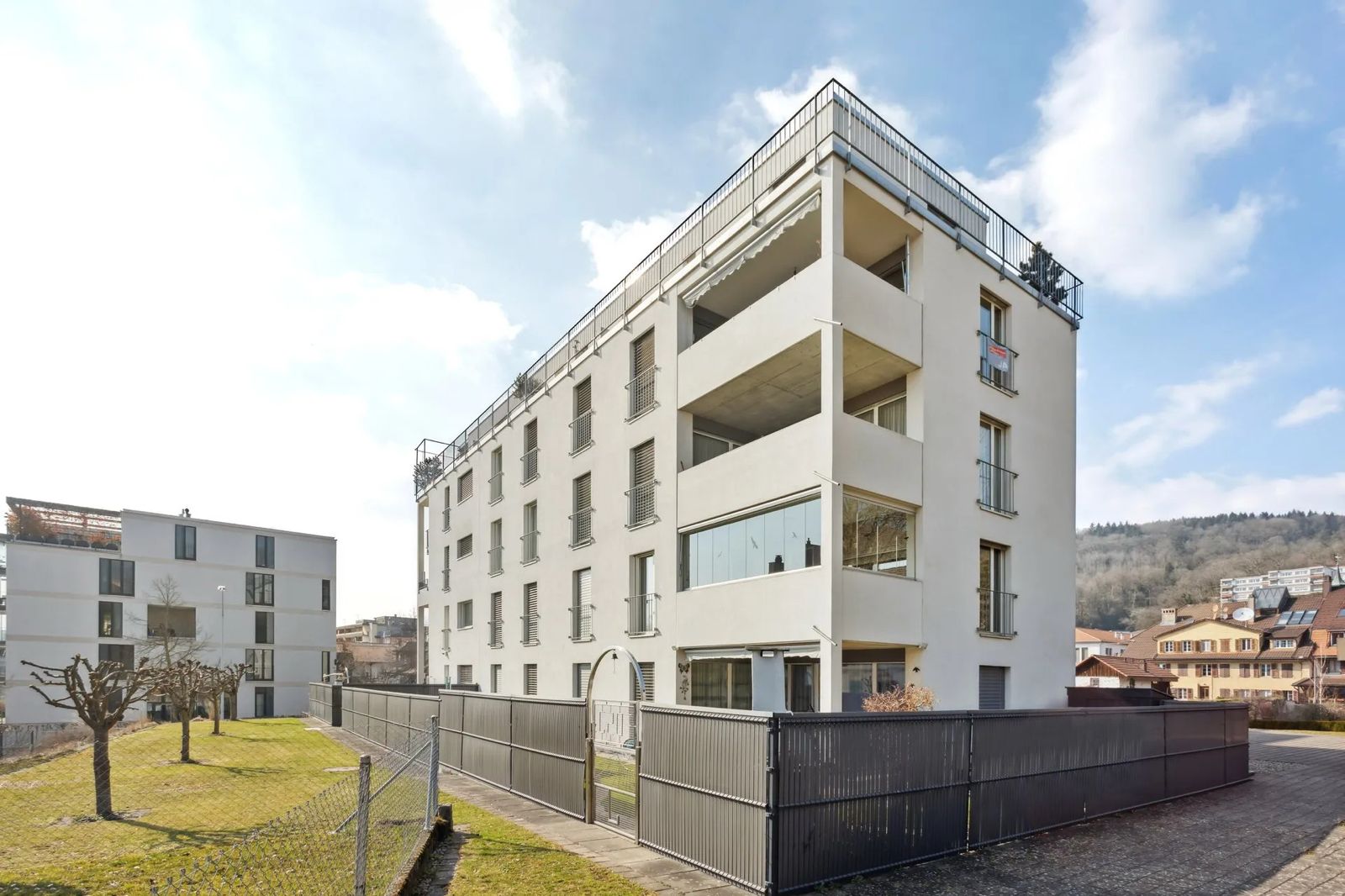 Mehrfamilienhaus mit Balkon und umgebendem Garten