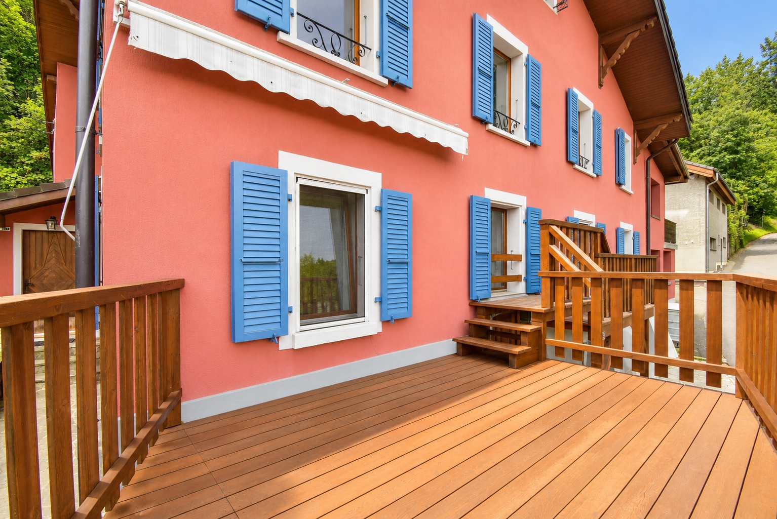 Balkon mit Holzbelag und bunten Fensterläden