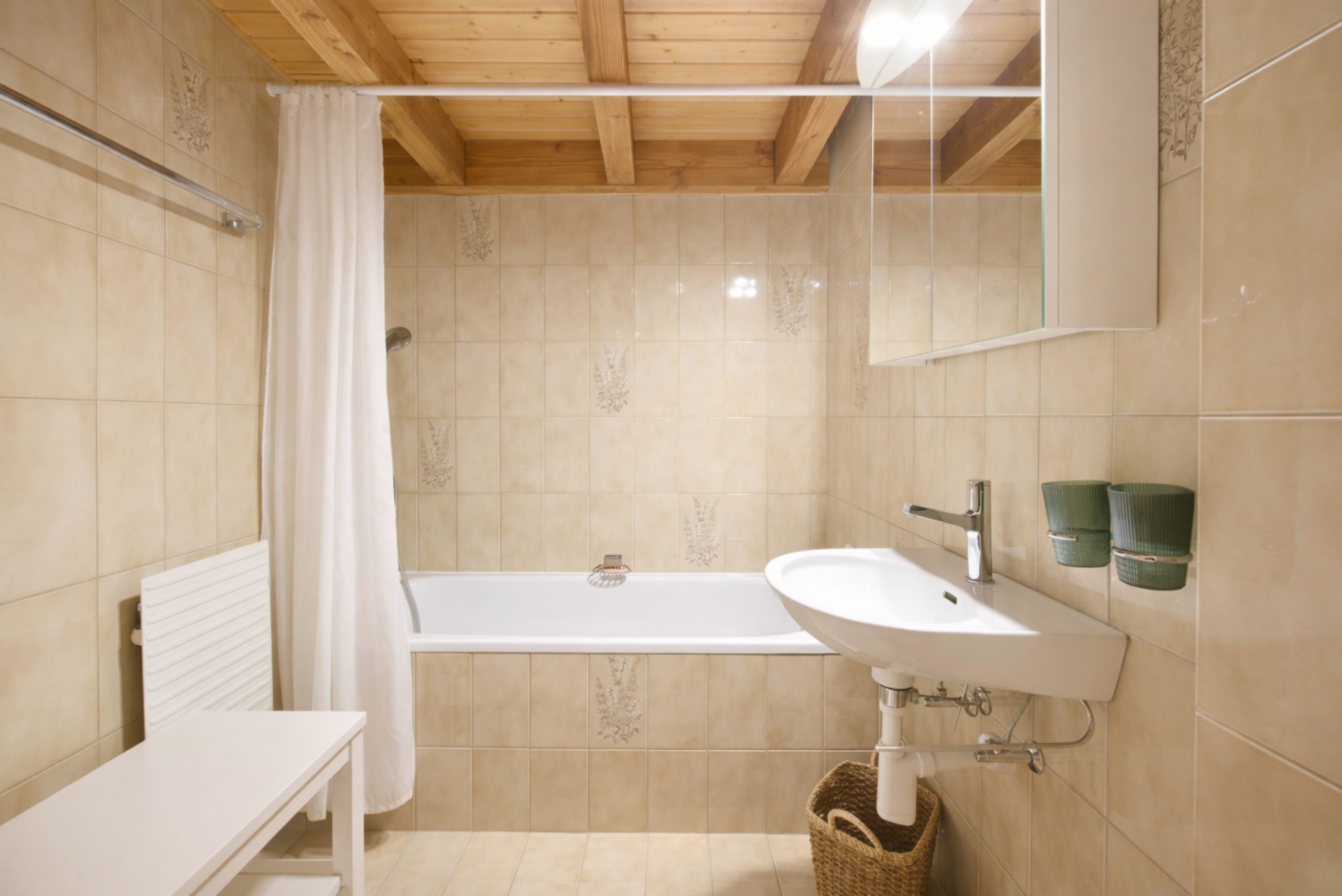 Badezimmer mit Badewanne und Dachbalken